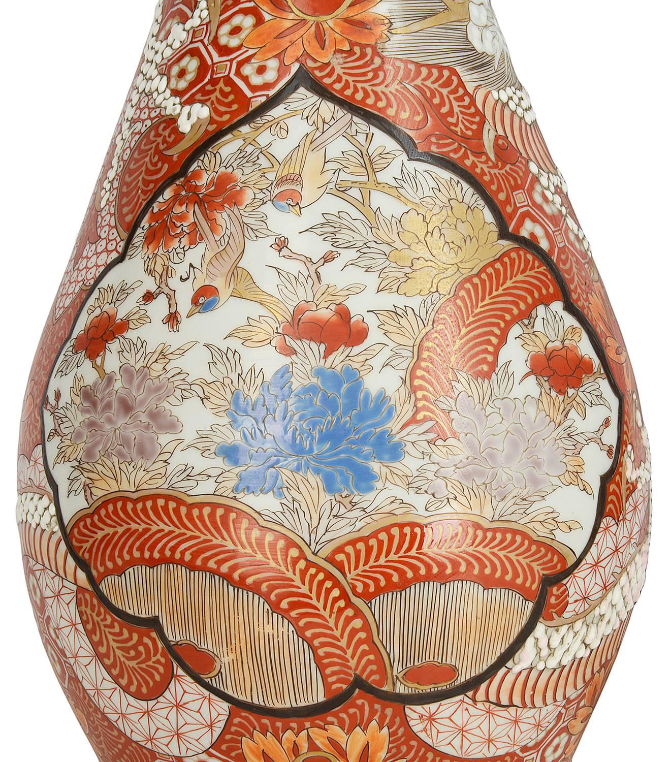 Ein dekoratives Paar japanischer Kutani-Vasen aus dem 19. Jahrhundert von guter Qualität, die jeweils mythische Drachen zeigen, die sich zwischen Blumen und Moiten um die Vasen winden.