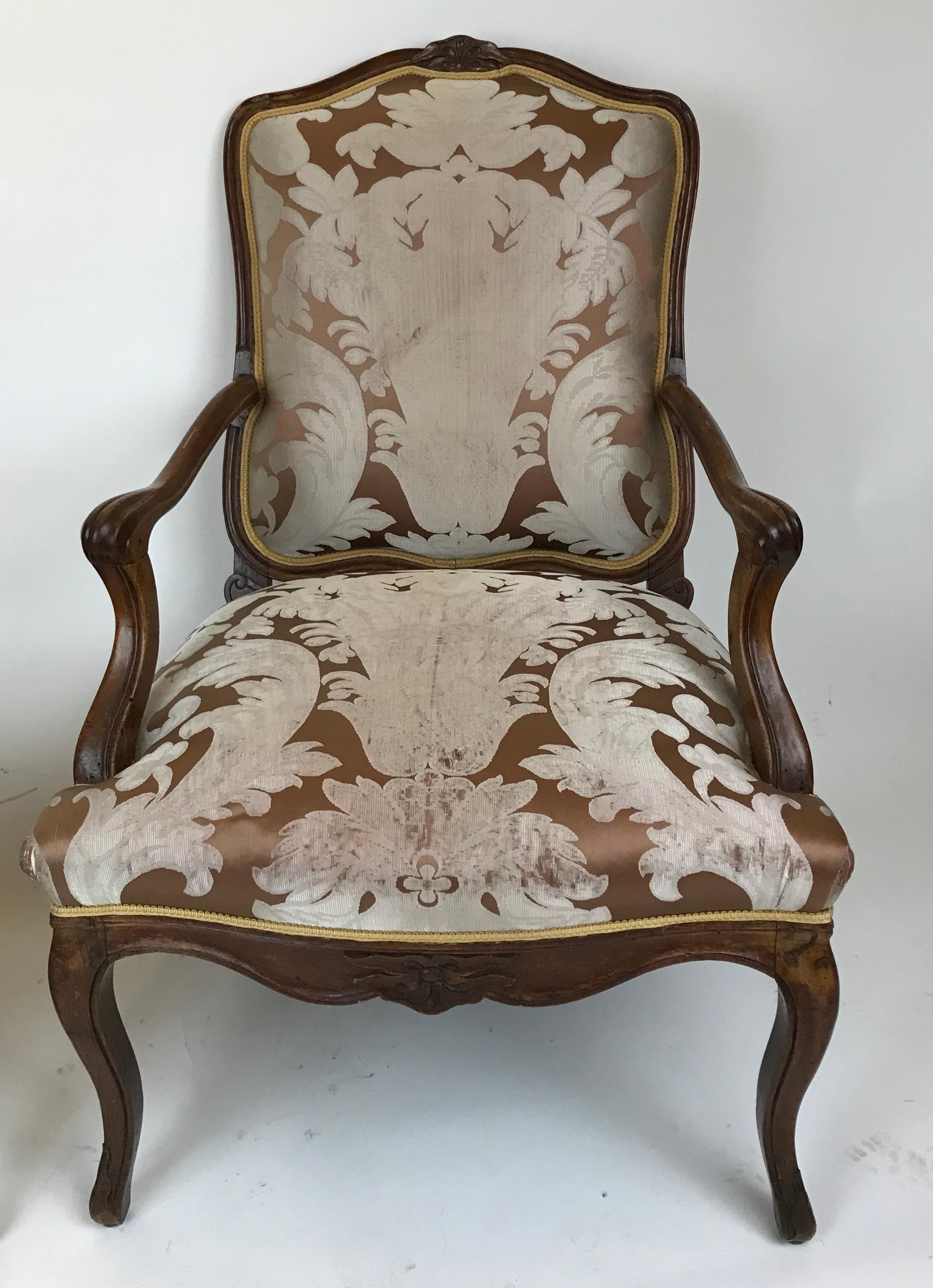 This pair of carved fruitwood French provincial open arm chairs are of generous proportion, and feature cabriole legs, and carved crest rails.
The upholstery shows signs of wear.