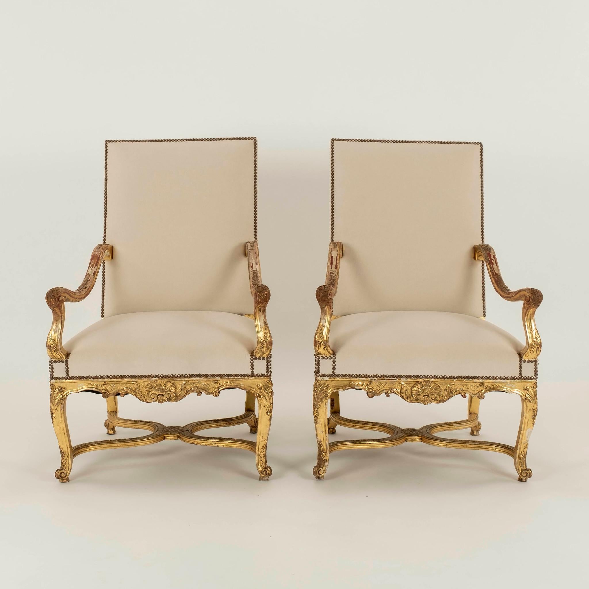 Paire de fauteuils en bois doré de style Louis XV du 19ème siècle, nouvellement tapissés d'un velours écru crémeux avec des détails en tête de clous. Également disponible C.I.C.
   