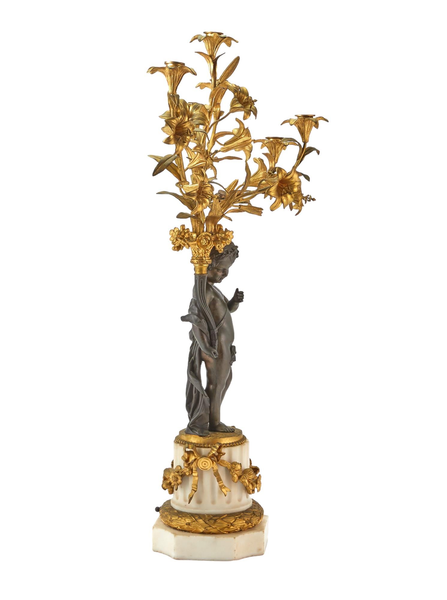Pair of large  (19th century) five light candelabra in the French Louis XVI style with standing patinated bronze cherubs set upon carved white marble pedestals adorned with gilt bronze garland.  Designed for electricity but apparently sockets and