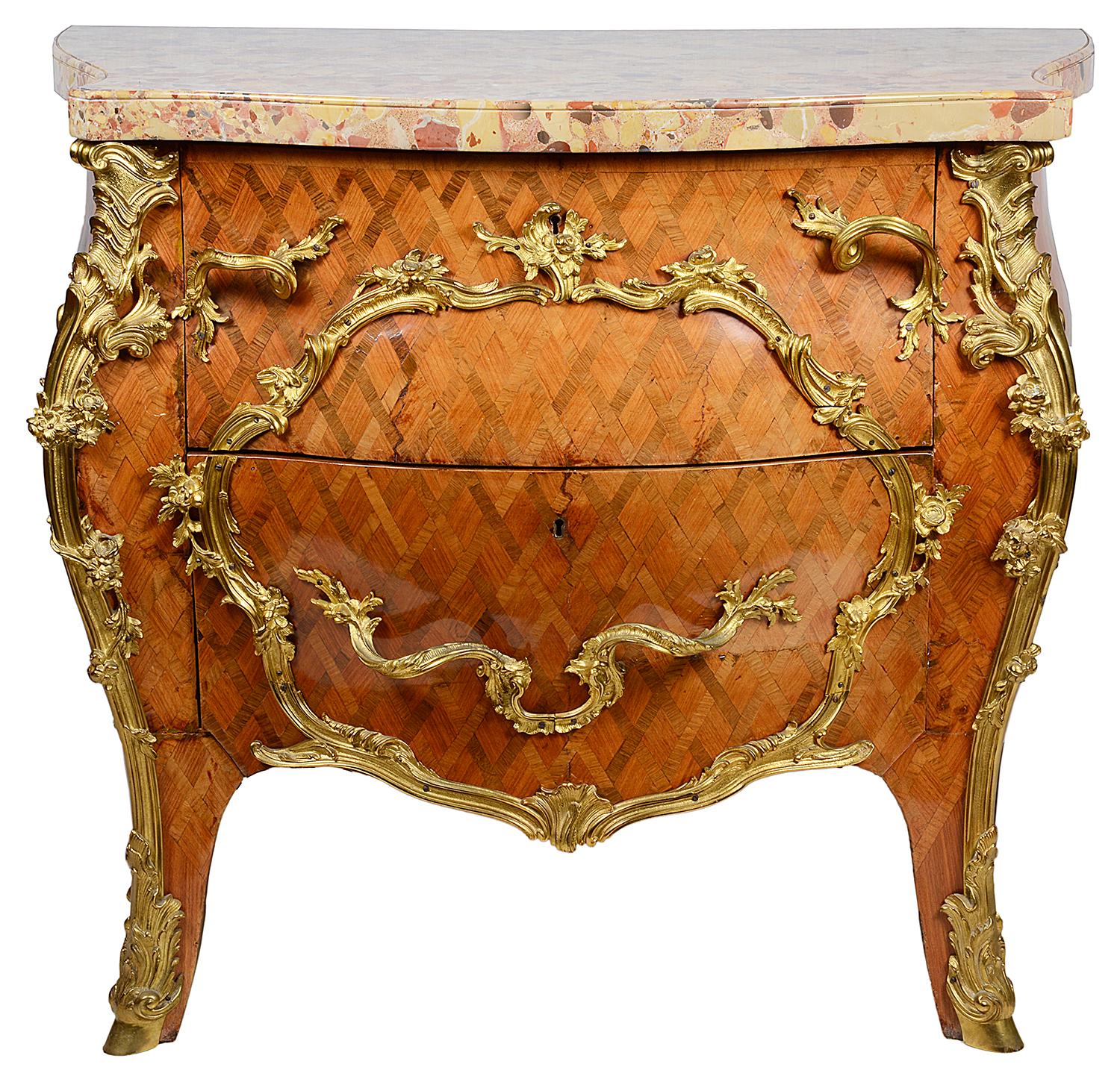 A good quality pair of French 18th century style parquetry inlaid bombe fronted marble topped commodes, each with Rococo influenced gilded ormolu mounts two Oak lined drawers and raised on out swept feet.