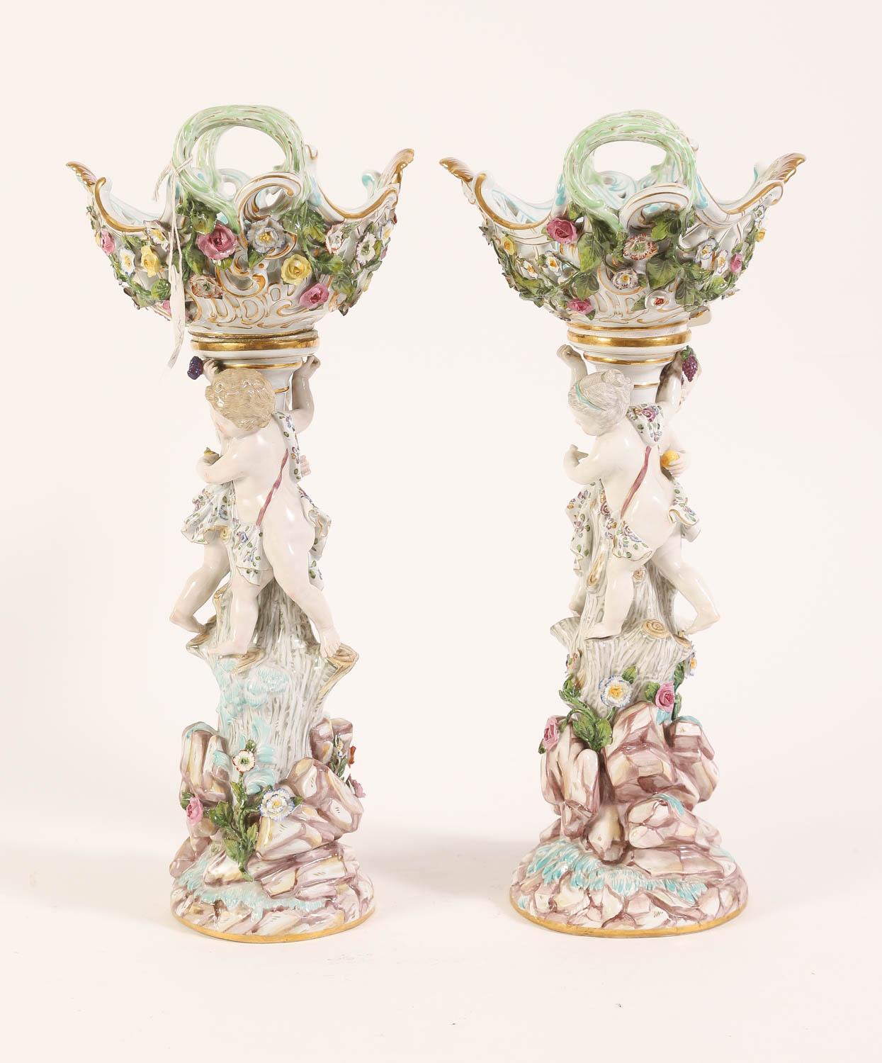 Pair of antique (late 19th century) reticulated porcelain baskets supported by putti around a tree stump, and encrusted with raised flowers.  Each 16 inches tall. Each with the Meissen mark and one incised A49.