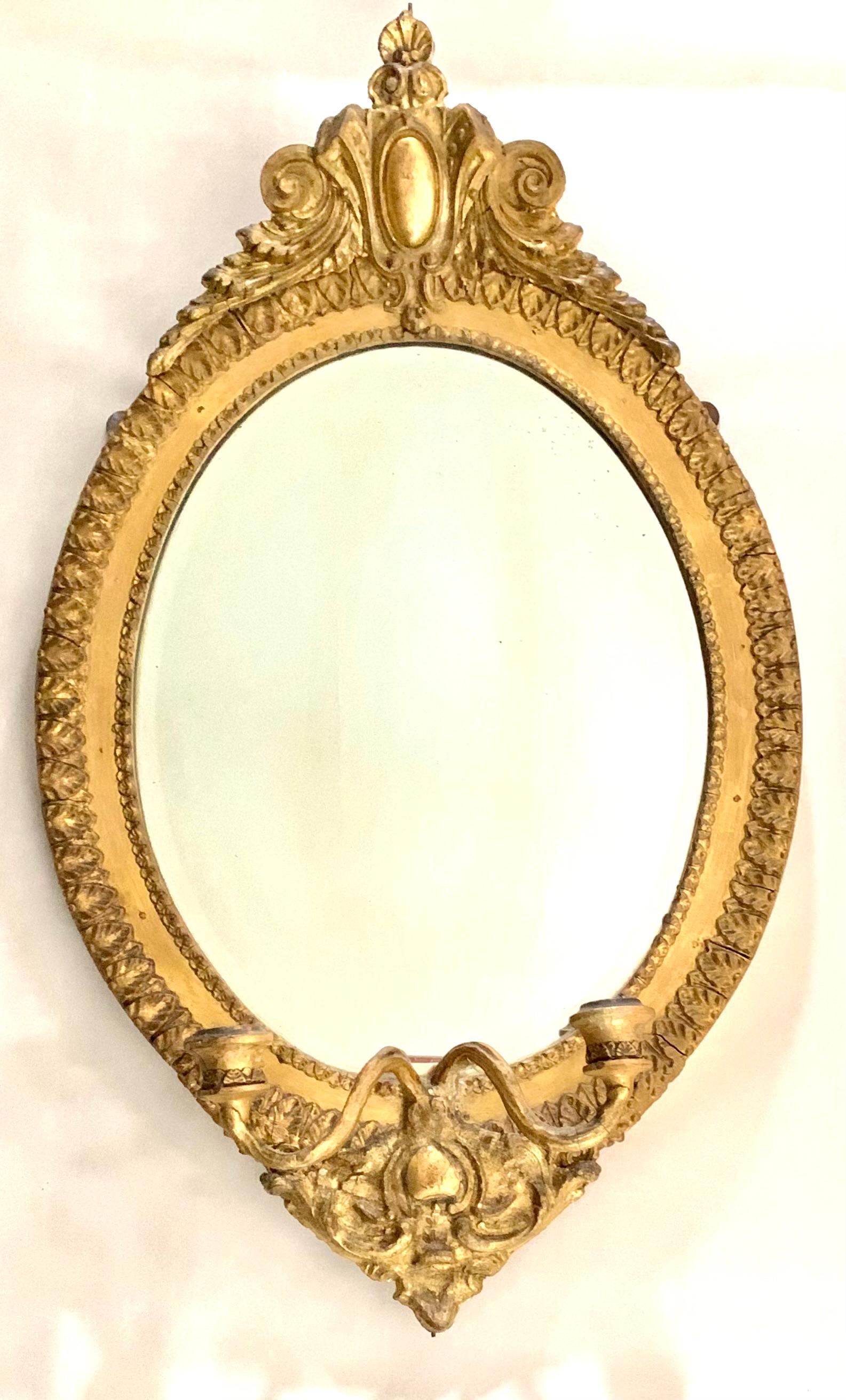Elegant pair of 19th century Continental Neoclassical style giltwood oval girandole mirrors
Each with an acanthus leaf border, the crest centered by an oval medallion topped with a Venus shell and flanked by attractive scrolled foliate design
