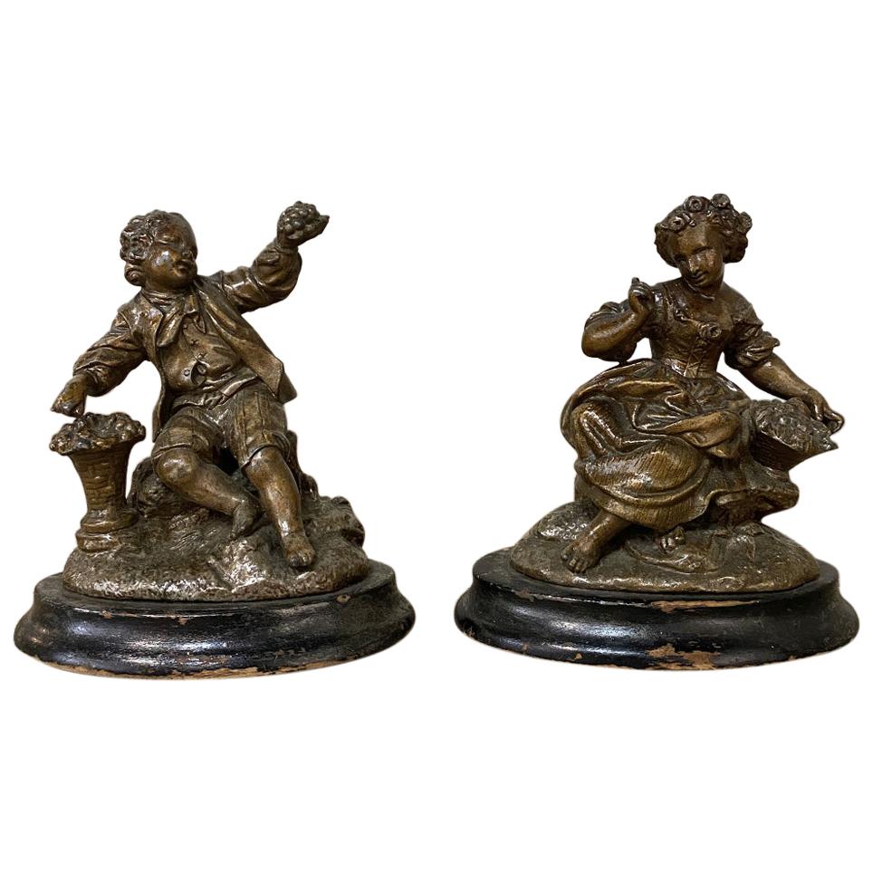 Zwei zierliche Statuen aus Zinn aus dem 19. Jahrhundert eignen sich auch hervorragend als antike Buchstützen! Die aus Zinn gegossenen und mit patinierter Bronze überzogenen Figuren, die auf polierten Holzsockeln stehen, zeigen jeweils einen Höfling