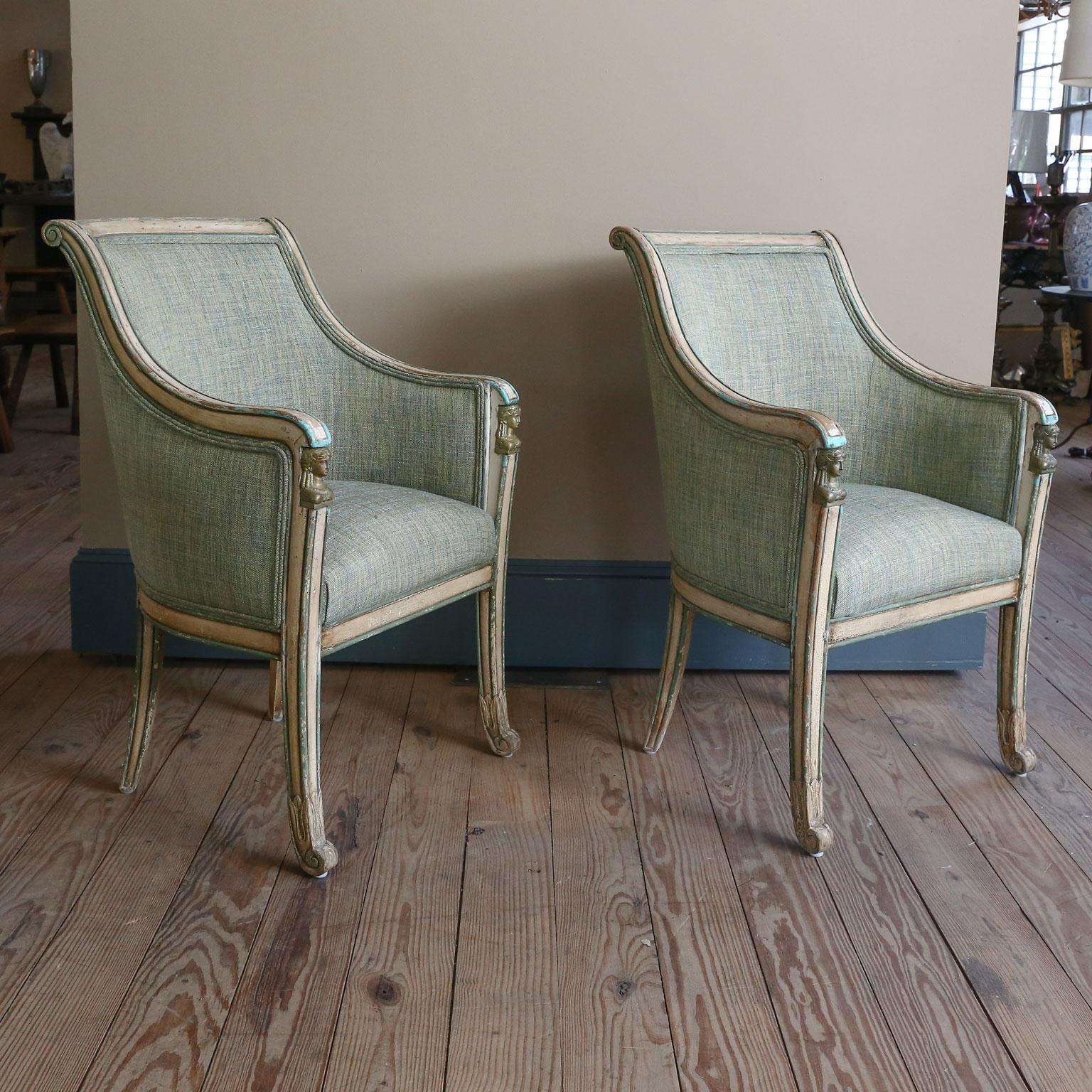 These fabulous pair of chairs have their original painted finish and a cast brass piece under each arm. I am not sure if that piece is Classical Greek, Roman or Egyptian. They have been newly restored and upholstered. Naturally, the fabric may not