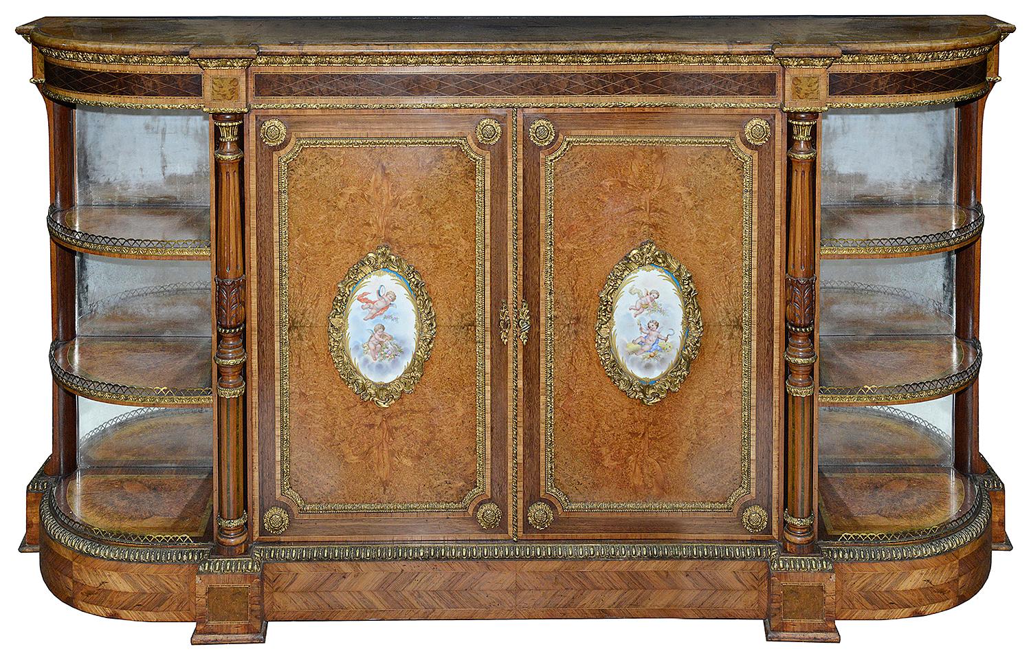 A very good quality pair of 19th century Sèvres mounted amboyna credenzas, having wonderful ormolu mounts, cross banded in Kingwood, carved columns and mirror backed open shelves to the sides.