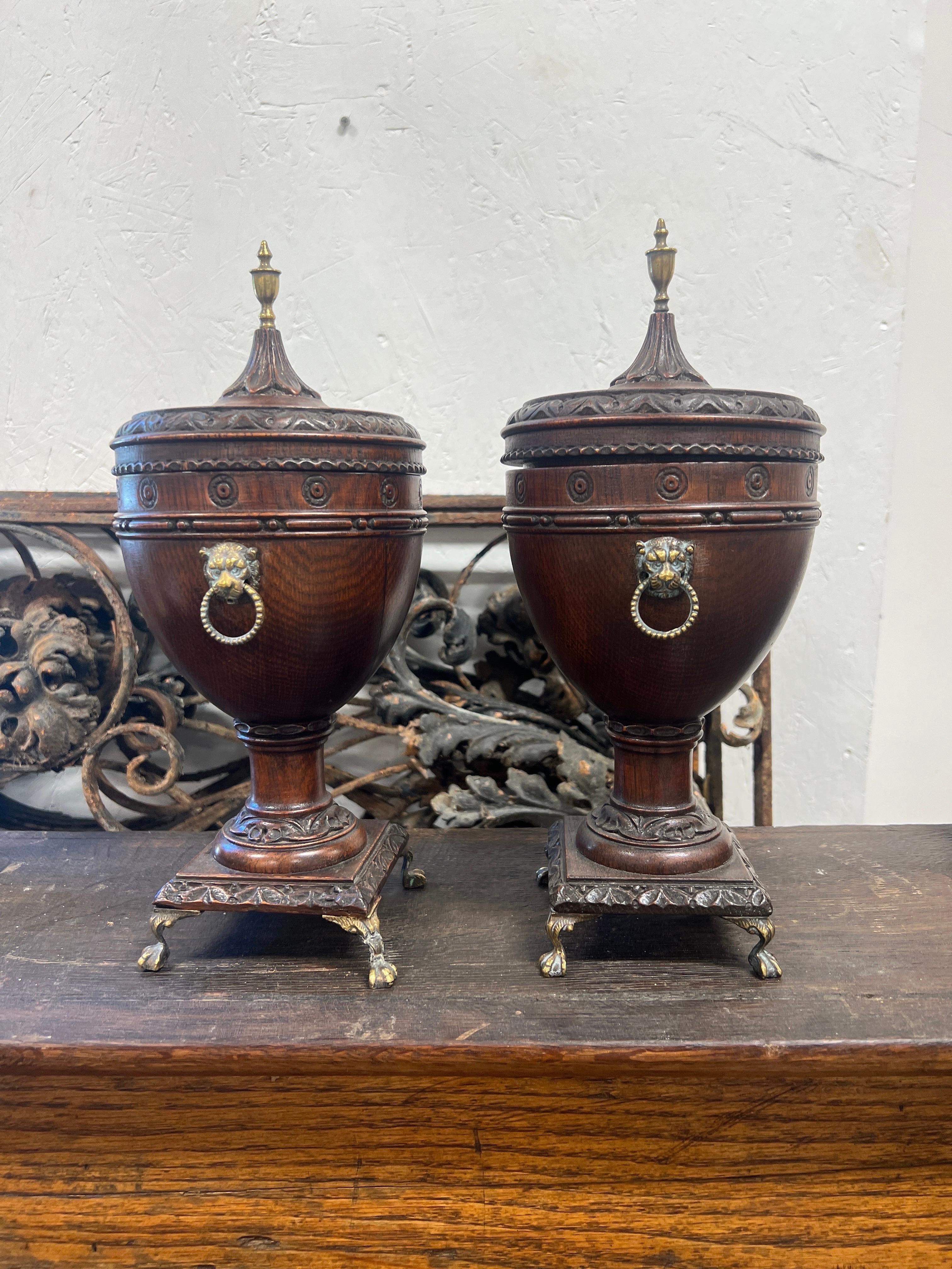 Britannique Paire d'urnes en chêne à couvercle monté sur un lion en laiton de style Régence du 19e siècle en vente