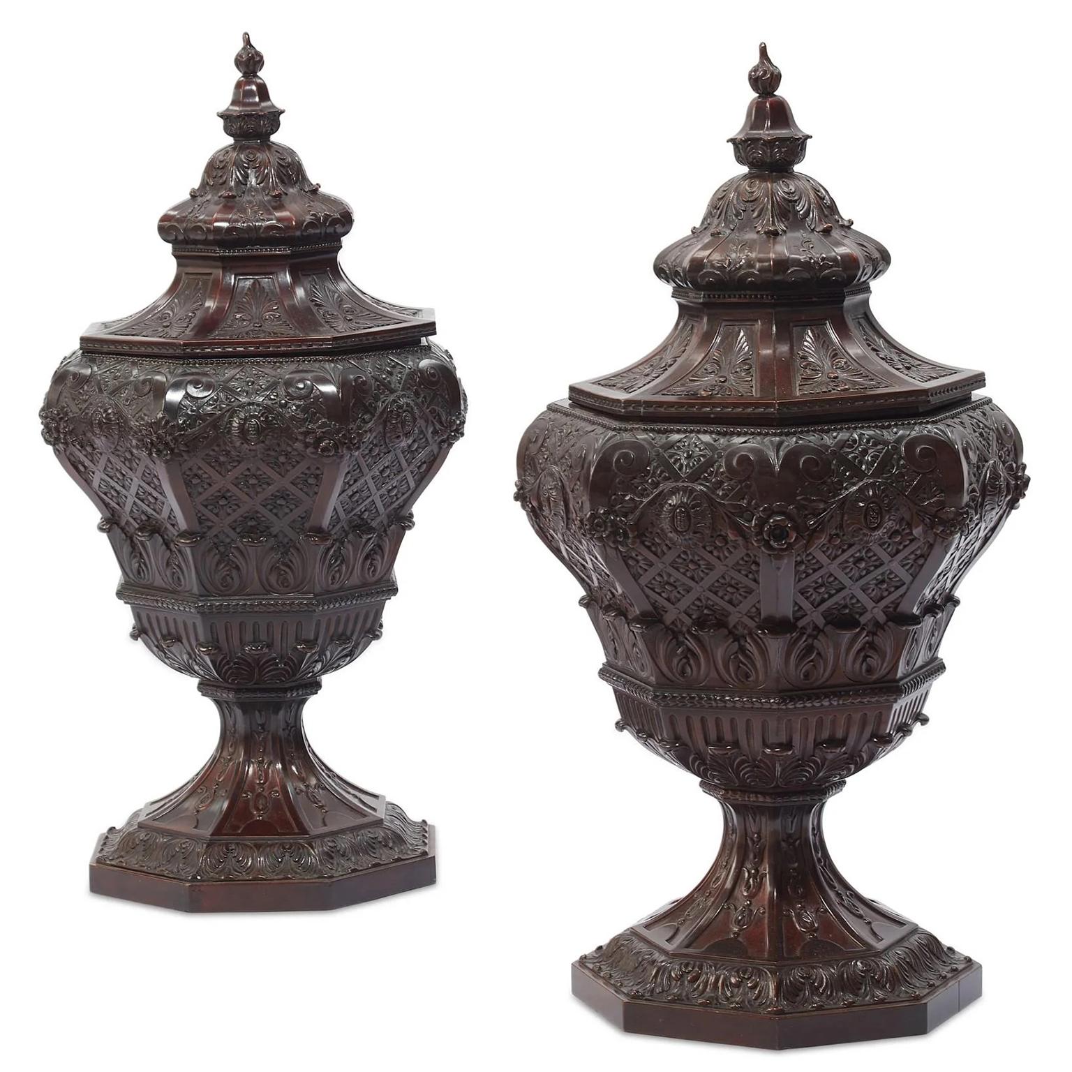 A very fine and rare pair of 19th century Regency style carved mahogany Cellarette urns or wine-drink coolers. The intricately carved ovoid shaped urn, decorated with acanthus leaves, wreaths and lilies, the removable lid top with a carved acorn