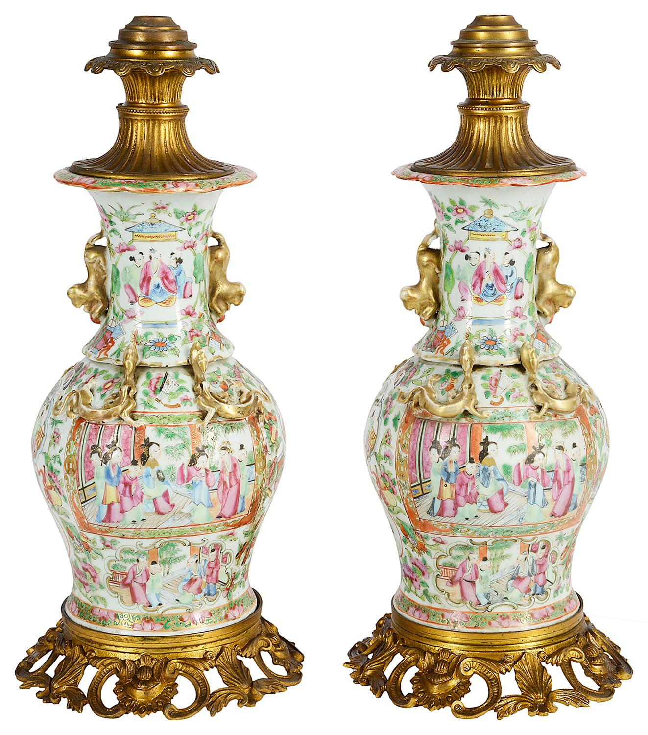 A good quality pair of Chinese Cantonese / rose medallion bellied vases / lamps. Each with wonderful gilded ormolu scrolling foliate mounts top and bottom. Dog of faux gilded porcelain handles on either side and lizards below. Inset painted panels