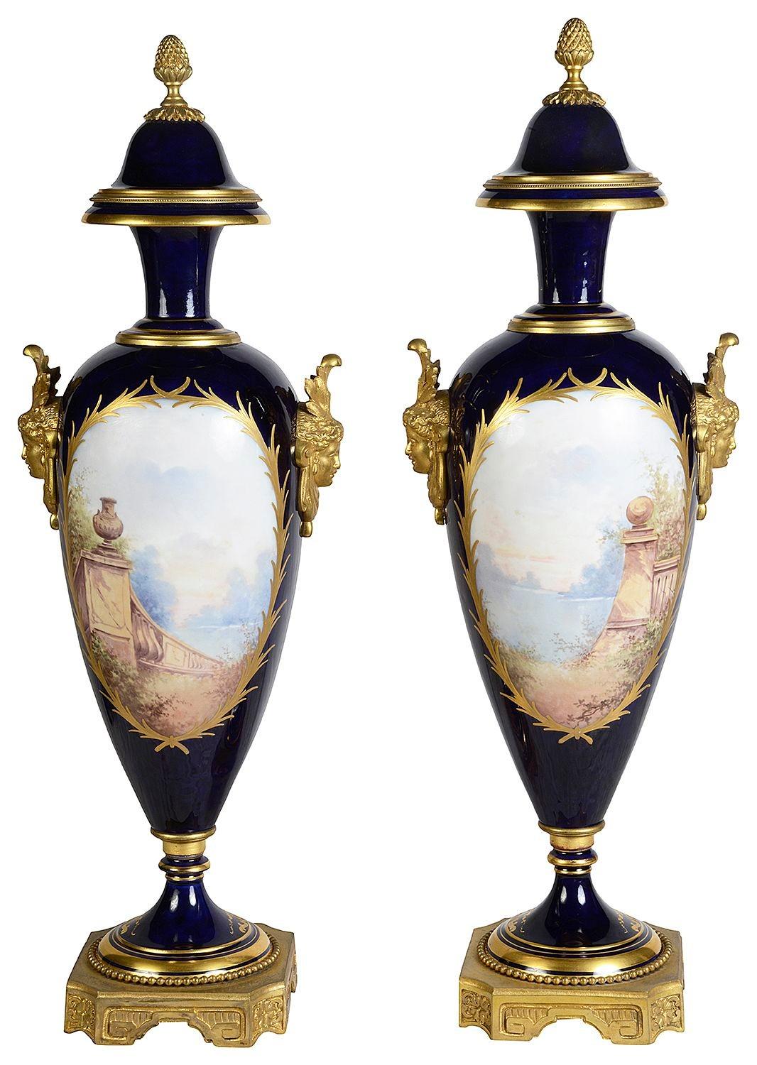 A good quality pair of late 19th Century French Sevres style porcelain lidded vases, each with gilded ormolu finials, mask handles and bases. Cobalt blue ground, gilded highlights and inset hand painted panels depicting of lovers and cherubs.

Batch
