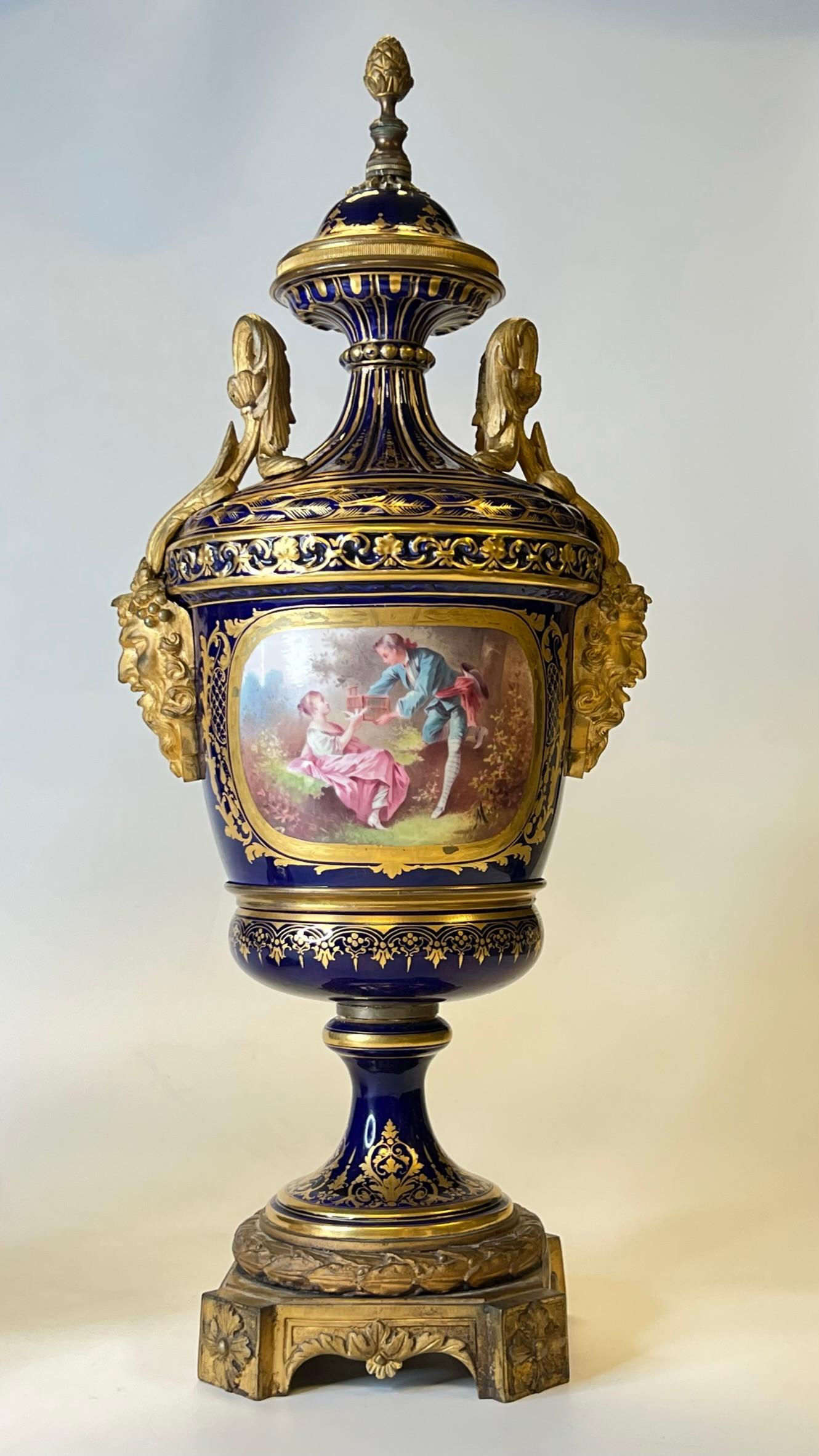 Pair 19th Century Sevres Style Gilt Bronze Mounted Urns in Louis XVI Style, cartouches signed Marchand with spurious Sevres marks on underside.