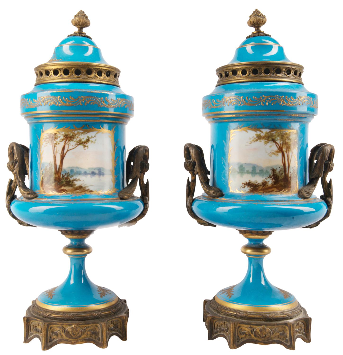 A good quality pair of French late 19th century French 'Sevres' style porcelain lidded urns. Each with gilded ormolu mounts, turquoise ground with gilt decoration. Inset painted panels depicting romantic scenes, raised on pedestal porcelain bases