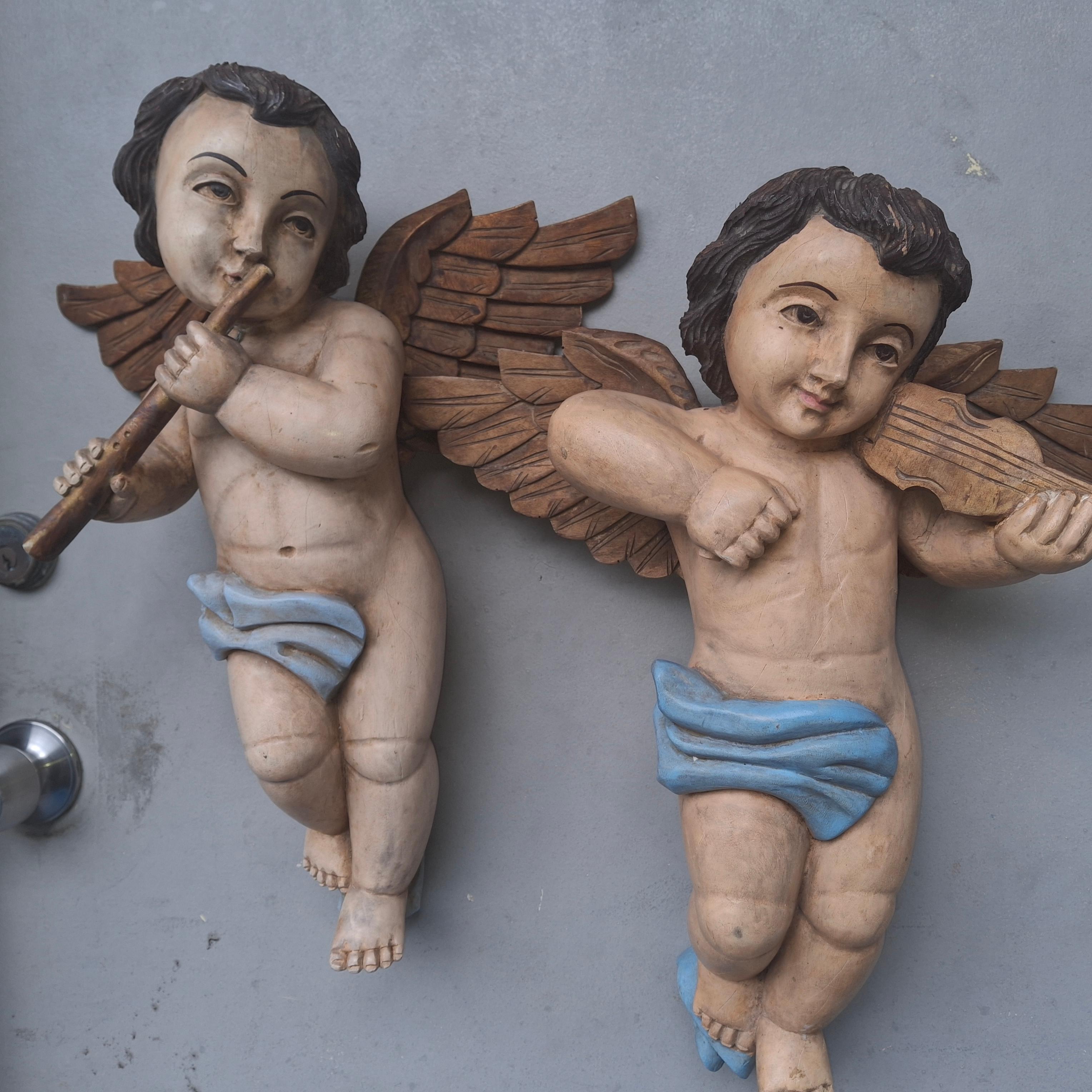 Coppia di grandi sculture di cherubini in legno intagliato e policromato in stile rinascimentale/barocco italiano del XIX secolo. Tenendo in mano i loro strumenti. Queste preziose figure sono grandi e si appendono magnificamente. Queste sono state