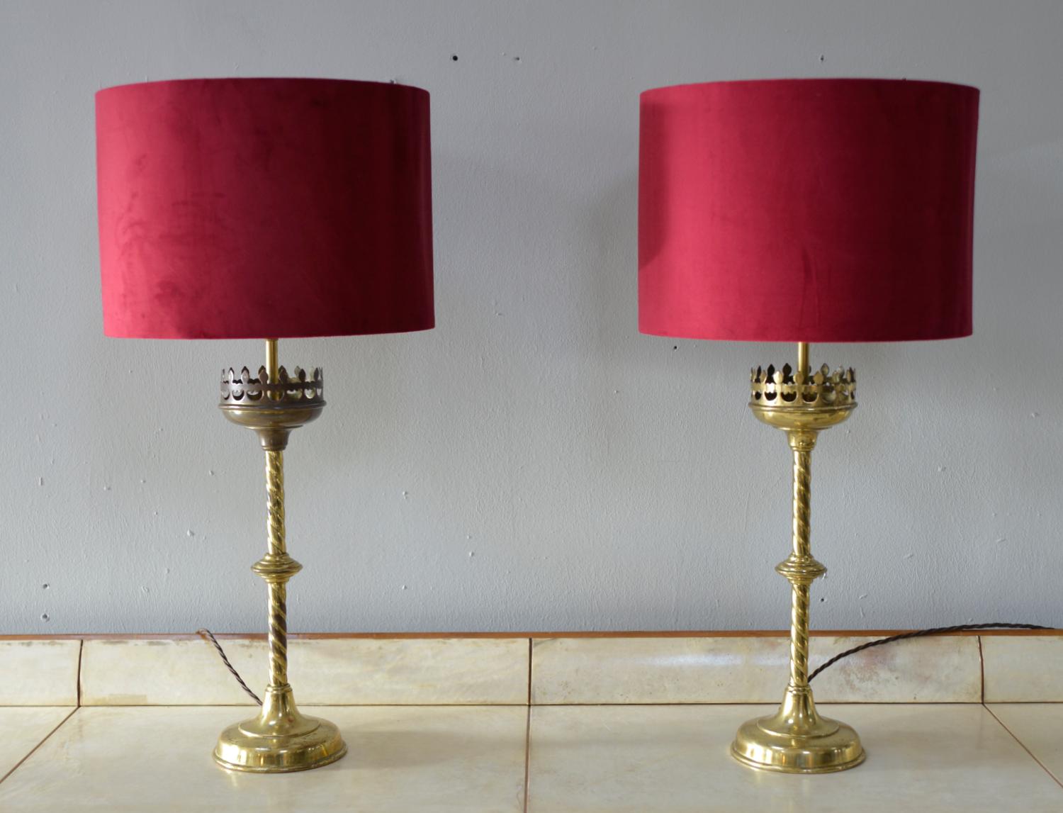 A pair of beautifully patinated Victorian Gothic Revival brass church candlesticks, with barley twist stems, which have been converted into table lamps. The candlesticks were bought as a pair in Belgium and have matching open-work Gothic