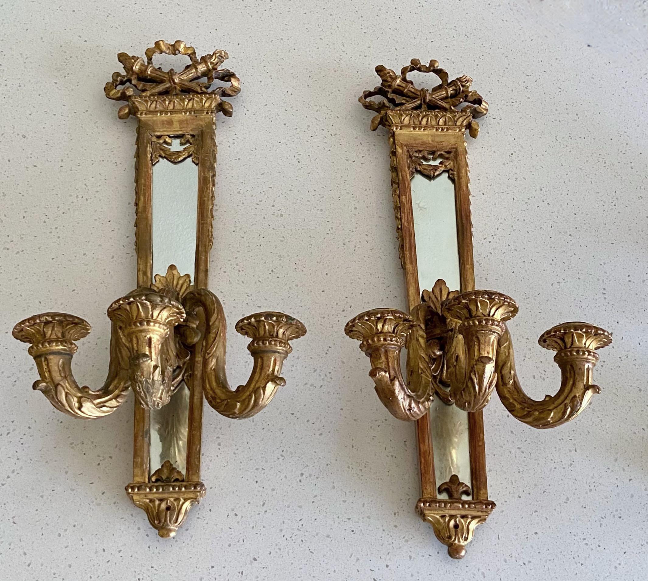 Pair of 19th century giltwood Louis XVI style three candle mirrored wall sconces (not electrified).