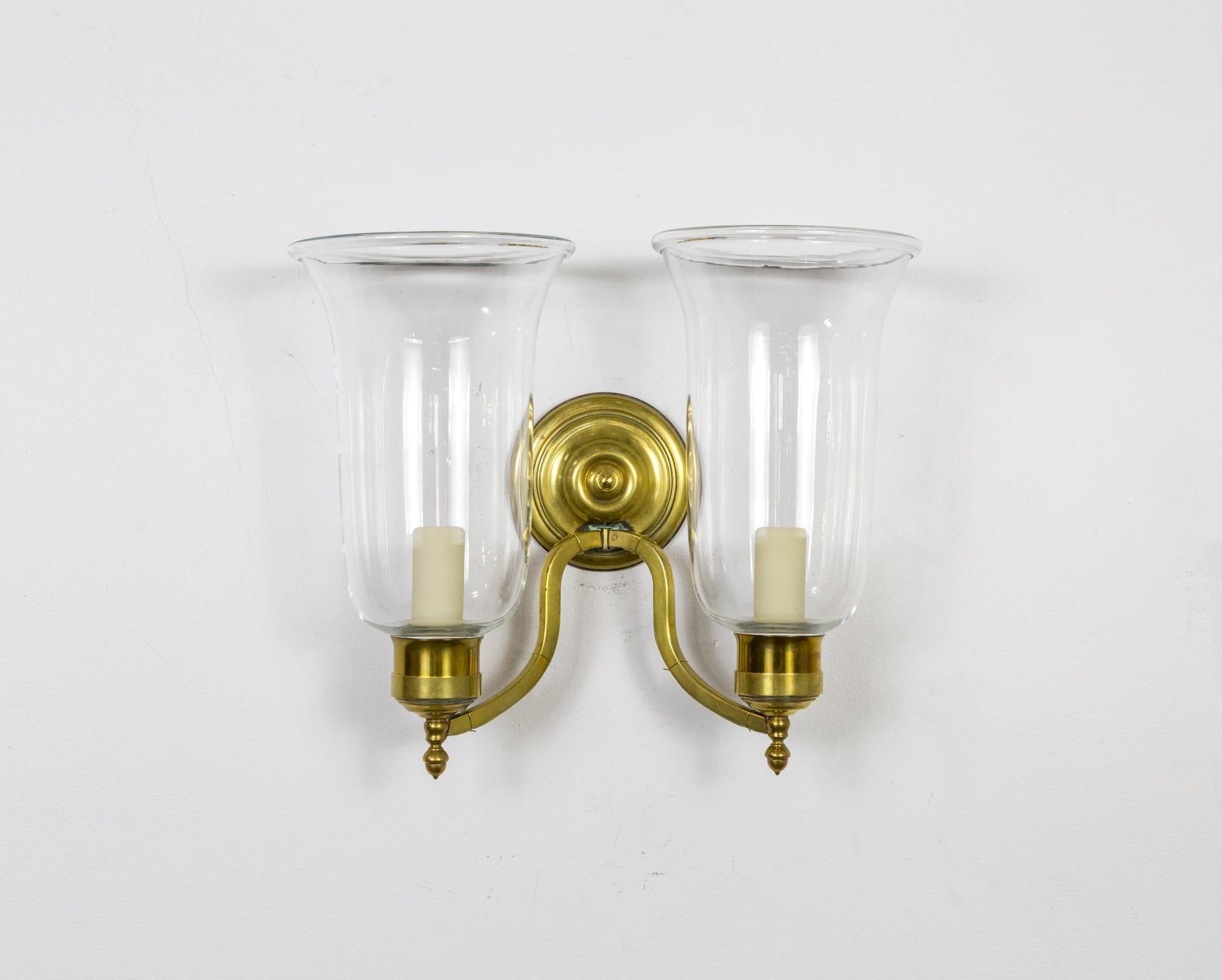 A fine pair of neoclassical style, extended double arm, brass sconces with heavy, blown glass chimney shades and rosette detail. American, 1980s. Recently restored and rewired.