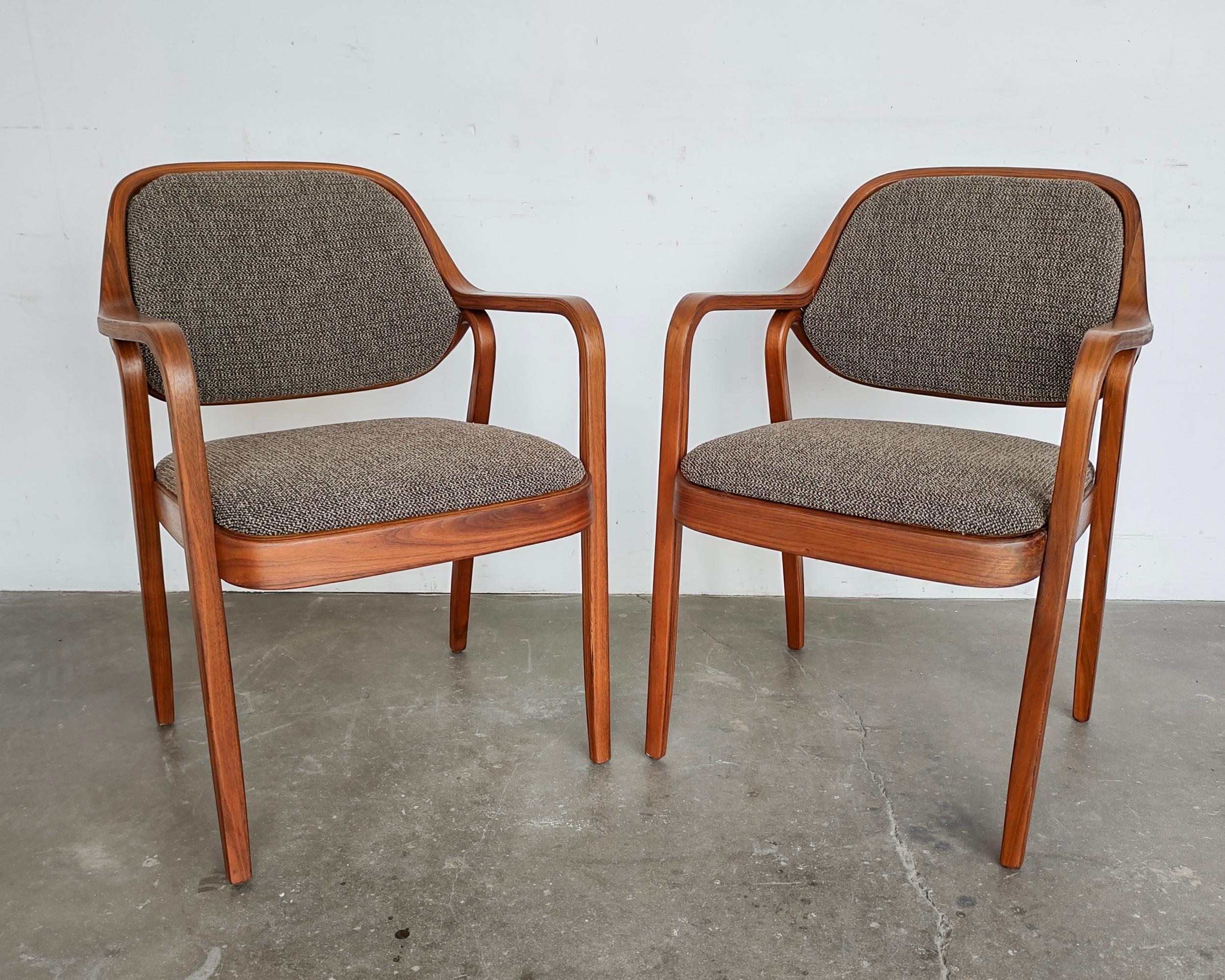 Set of two (2) '1105' bentwood walnut arm chairs by Don Pettit for Knoll designed in 1965. Neutral tone tweed upholstery highlights the walnut beautifully. Frame is made up of three separate pieces of bent walnut plywood, there are some minor