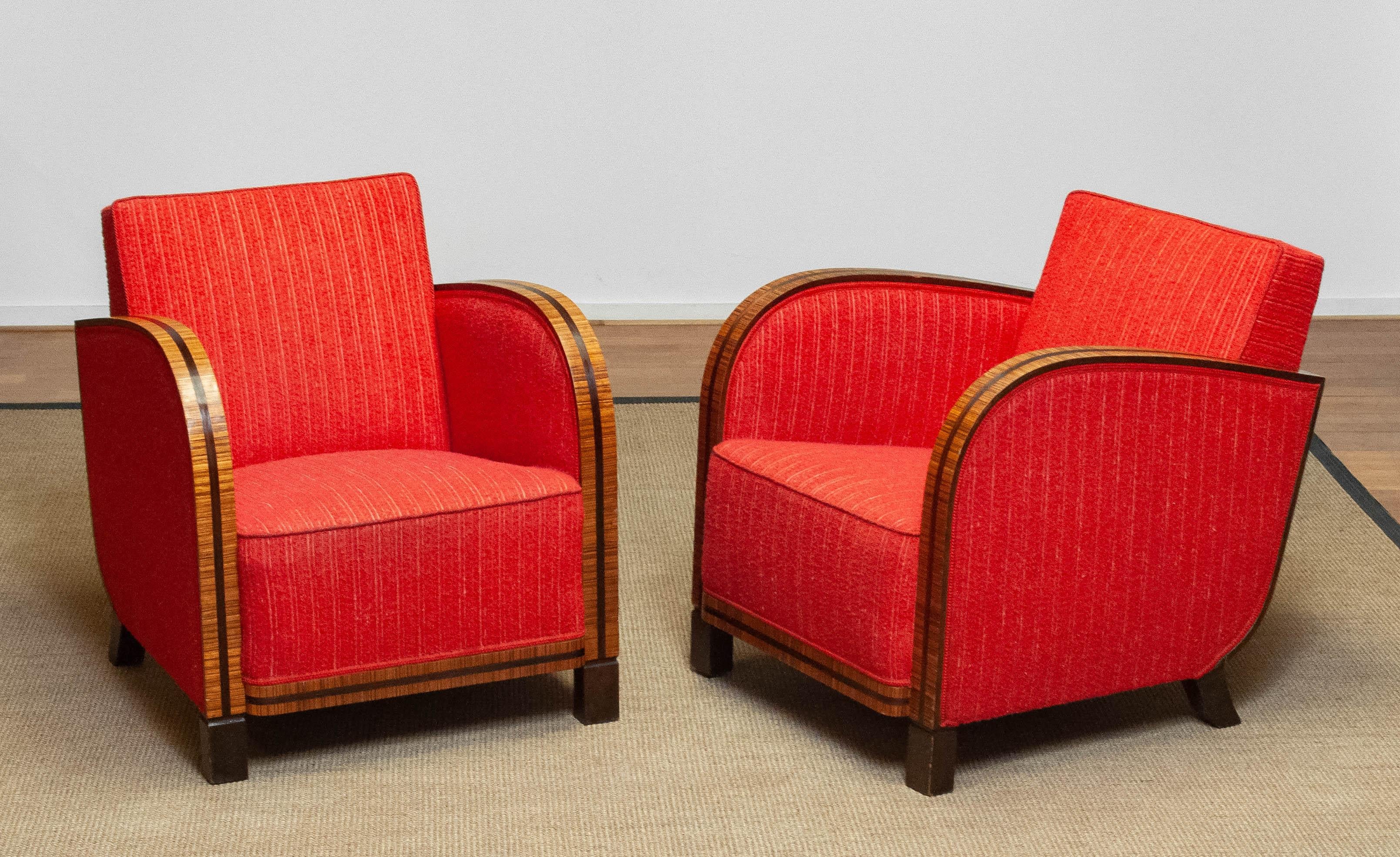 Absolutely beautiful and rare set of two club / lounge chairs both in good and original condition. The red bouclé fabric is still in good and clean condition. All springs and bindings are also in good condition and therefor these chairs supports