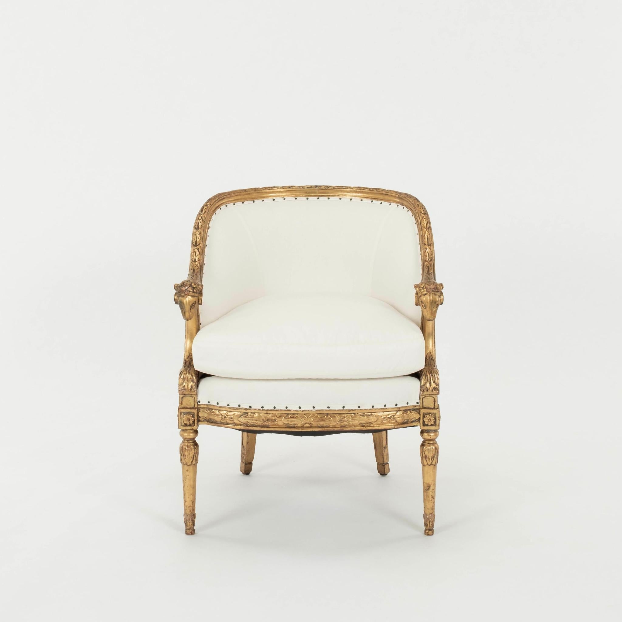 A pair of 20th Century classically styled gilt wood bergére chairs newly upholstered in a white cotton ticking fabric with feather down wrapped seat cushion.

These chairs also available C.O.M. with quick turnaround for additional $800.00.