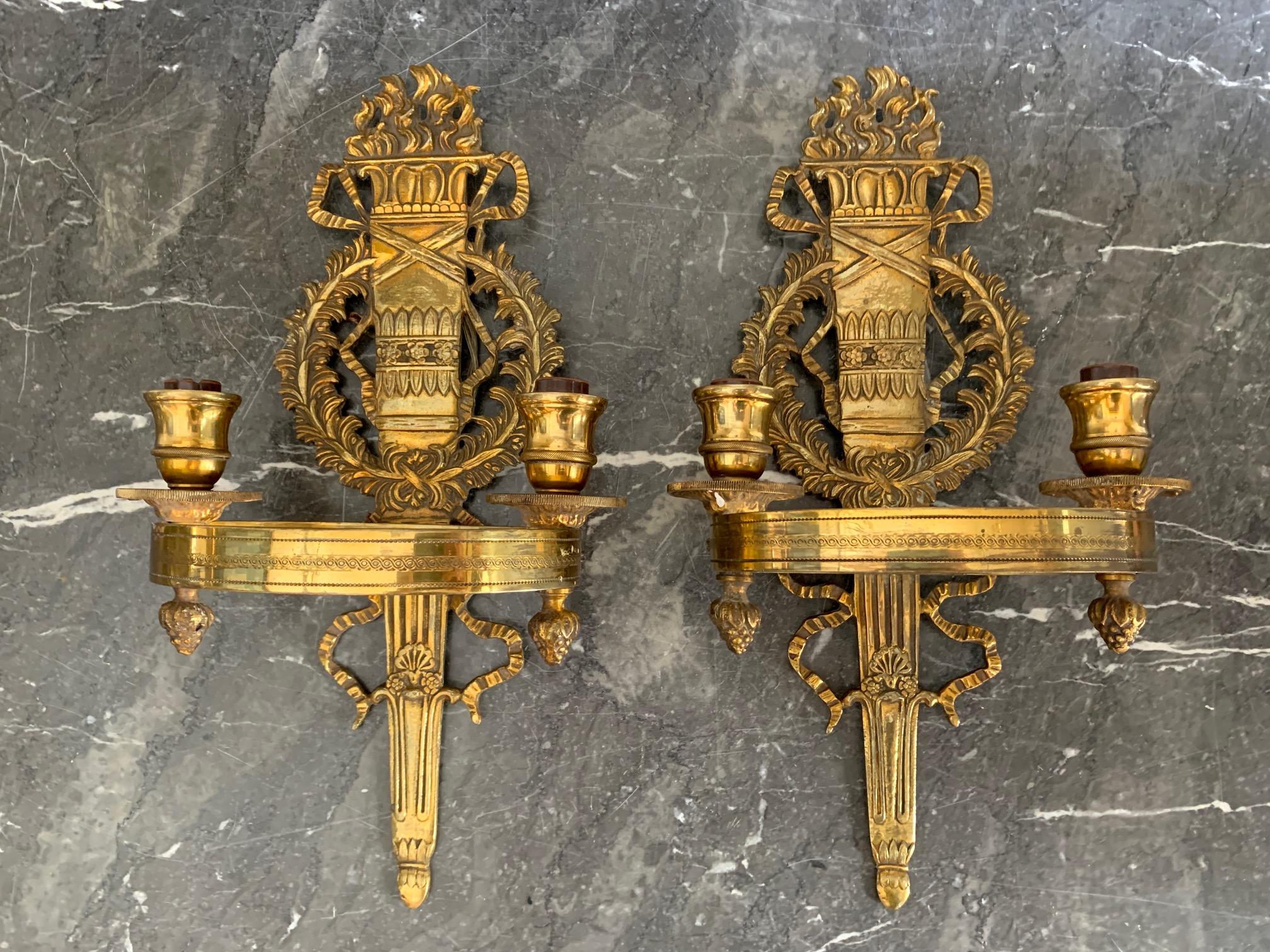 Pair of nicely detailed French Empire bronze style two-arm wall sconces with central flame and torch motif.