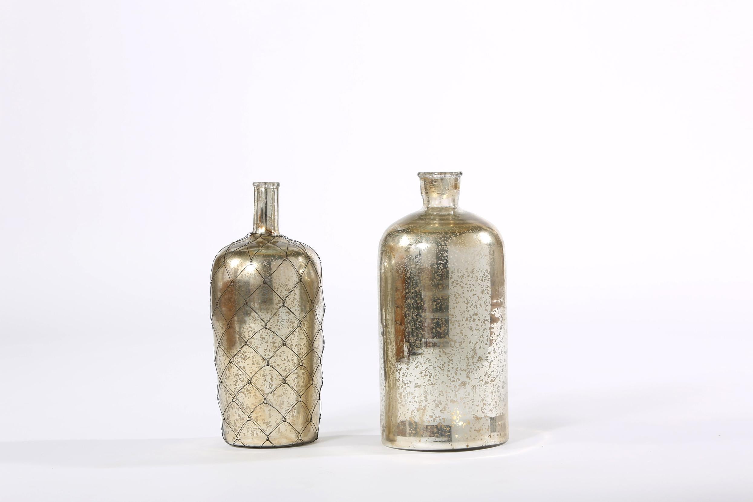 Pair of late 20th century mercury glass decorative bottles piece. Each bottle is in good vintage condition. Minor wear appropriate with age / use. Tall one stand about 15 inches tall x 7 inches base diameter. The other bottle stand about 14.5 inches