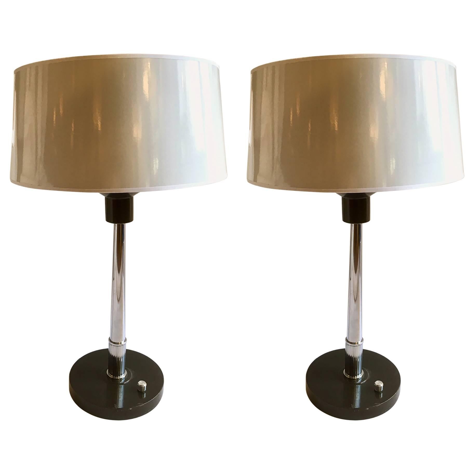 Paire de lampes de bureau ou de table, fabriquées en métal laqué dans sa base et colonne en métal chromé. Nuances en blanc.cuir verni, intérieur argenté.