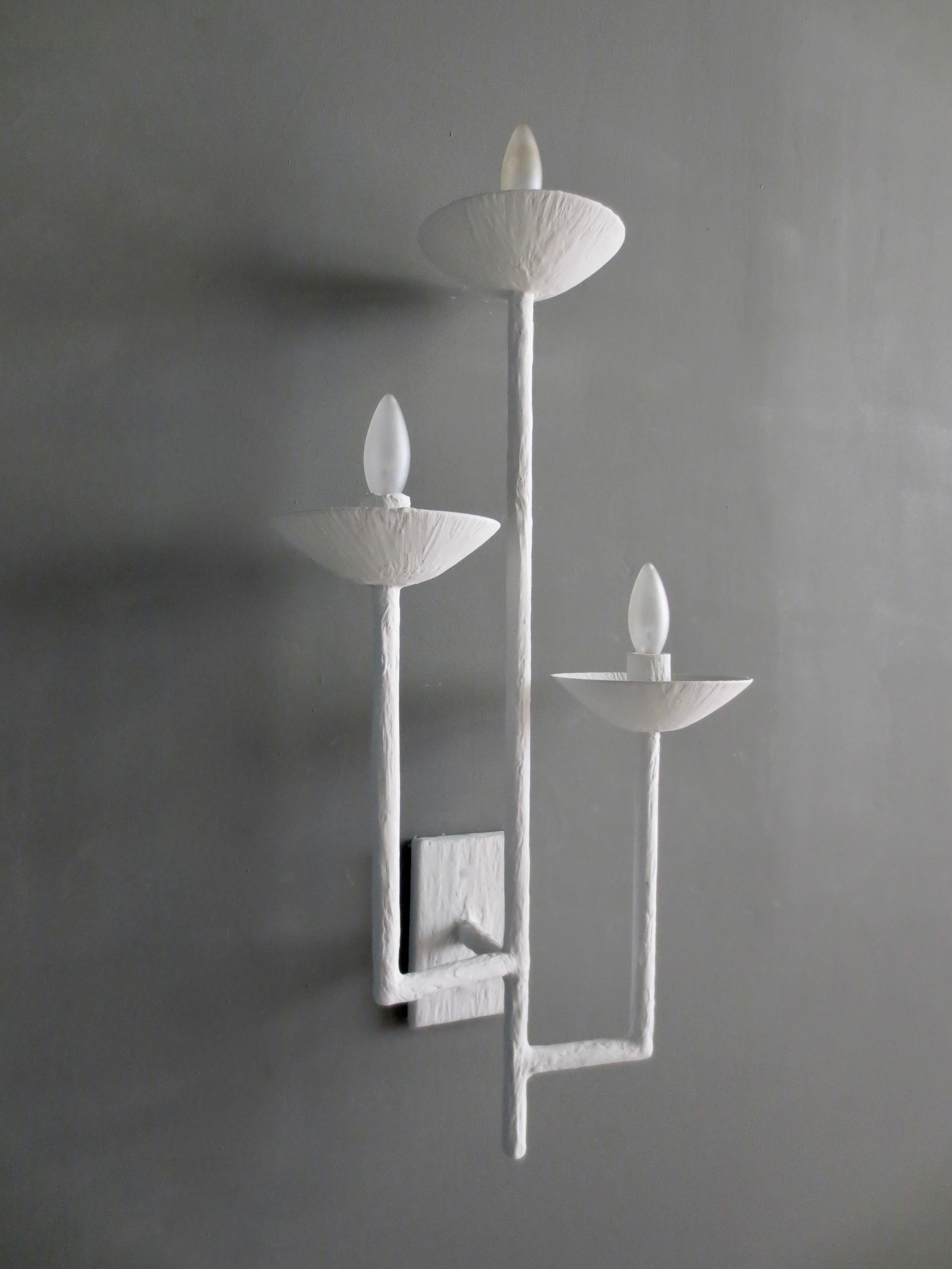 Paire d'appliques en plâtre à trois bras, réalisées par Tracey Garet d'Apsara Interior Design.
Chaque applique comporte 3 coupelles de hauteurs différentes et est présentée en plâtre blanc. Les coupes contiennent chacune un candélabre. Les