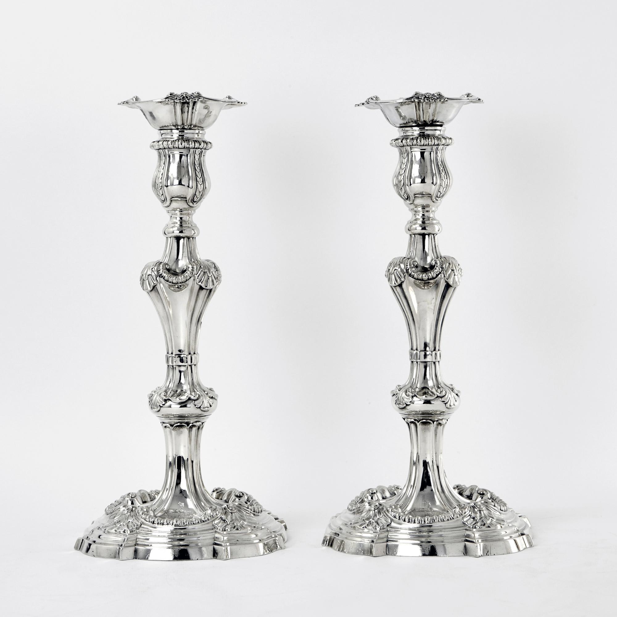 A spectacular pair of George III cast silver candlesticks made by Frederick Vonham in 1762 with the addition of a pair of 3-light arms by the same maker in 1771. The shaped, round bases have a border of four shell motifs connected by a heavy gadroon