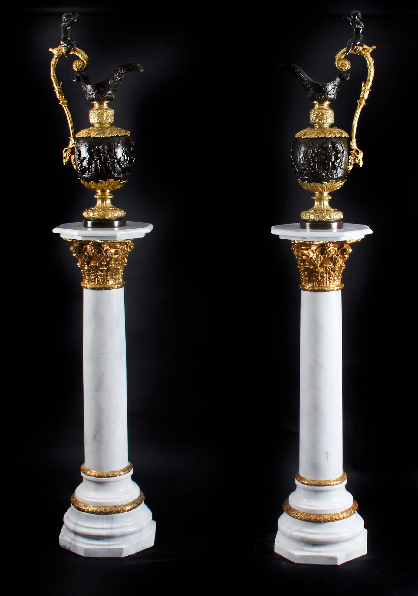 This is a gorgeous pair of 4ft white marble Corinthian column pedestals with gilded bronze 'ormolu' mounts, dating from the late 20th century.

In classical Empire Revival the pedestals would be perfect for displaying bronzes, marble statues or