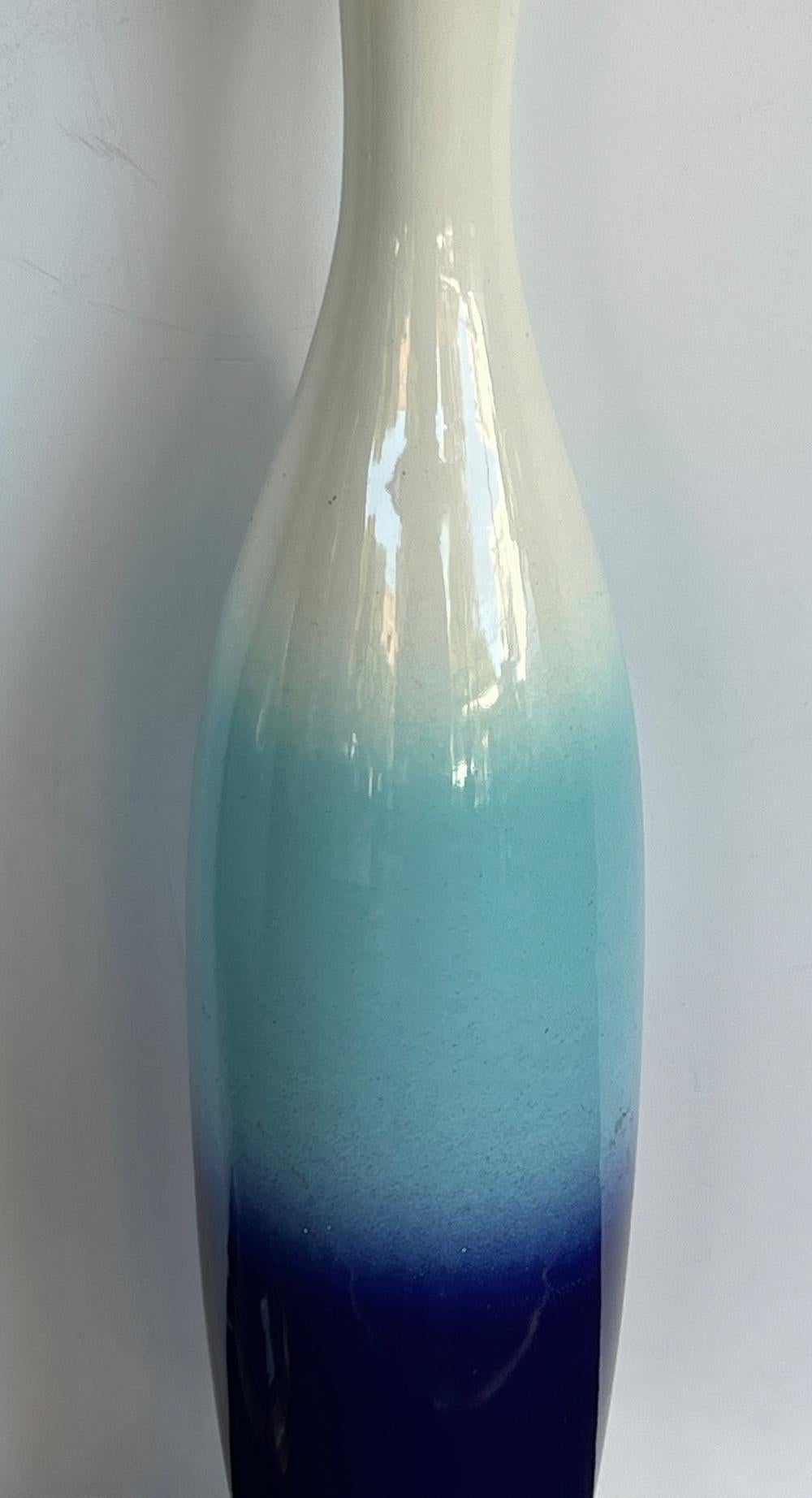 chaque lampe élancée en céramique en forme de bouteille avec une surface émaillée graduée d'ivoire, d'aqua et de bleu cobalt ; le tout reposant sur une base ronde en laiton