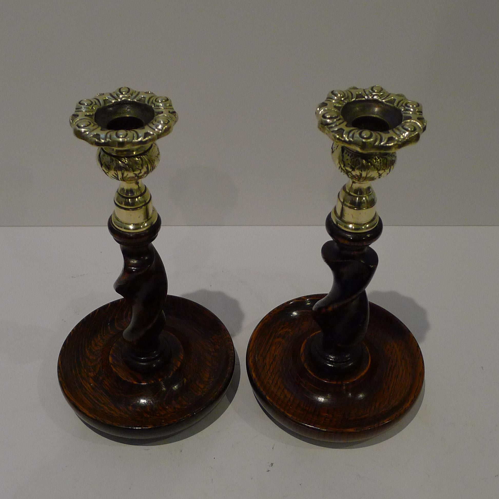 A wonderful pair of wooden candlesticks, always a winning combination, polished Oak and brass.

The English Oak has been skillfully carved in a spiraling barley twist design. The cast brass tops in the form of Scottish thistle form, protect the wood