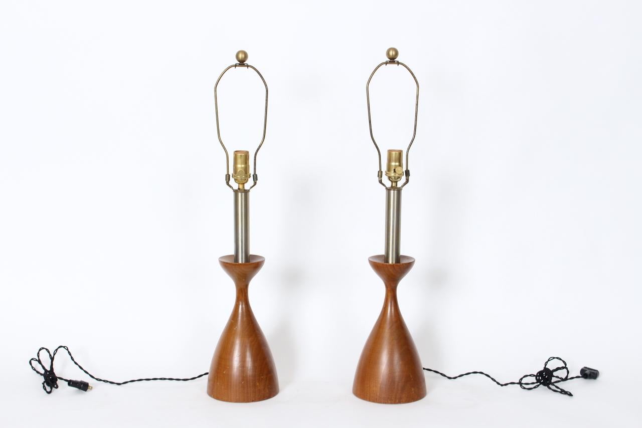 Paire de lampes de table de lecture en noyer et acier brossé, années 1950. Sa forme de sablier en noyer massif tourné est lisse et son manche est en acier brossé.  À la manière d'Adrian Pearsall. Architectural. Mouvement de l'artisanat américain.