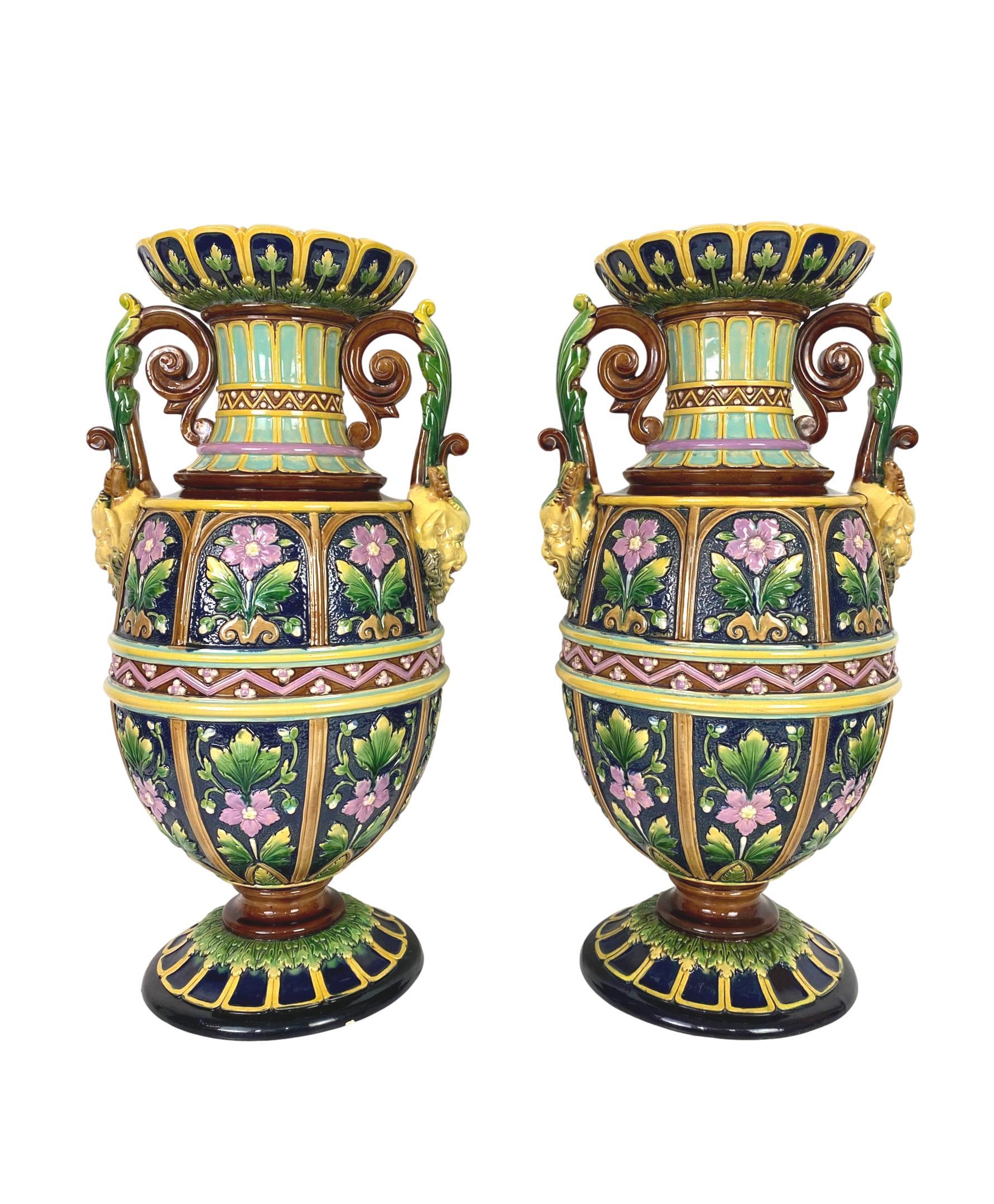 Impressive pair of aesthetic movement Majolica vases or urns signed Wilhelm Schiller and Son, Bohemia, circa 1880, measures: Height 17.25 inches.
Of baluster-form, the flared mouth with foliate panels glazed in yellow, green, and cobalt, with