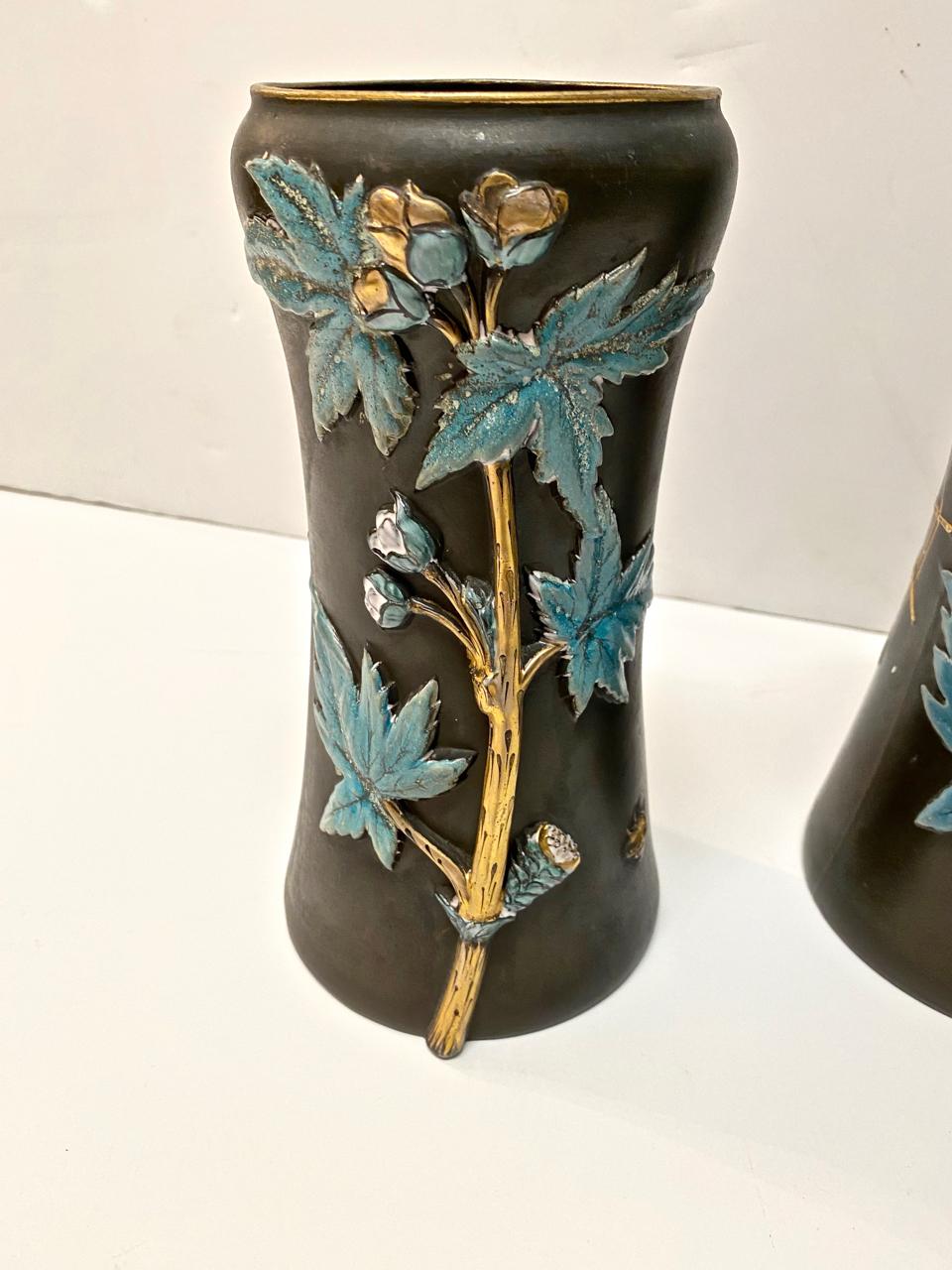 This is an unusual pair of aesthetic movement vases that date to circa 1880-1900. Both vases, although very similar, are not identical, they are decorated in raised applied florals and spiders. The vases are unmarked, but appear to be English in