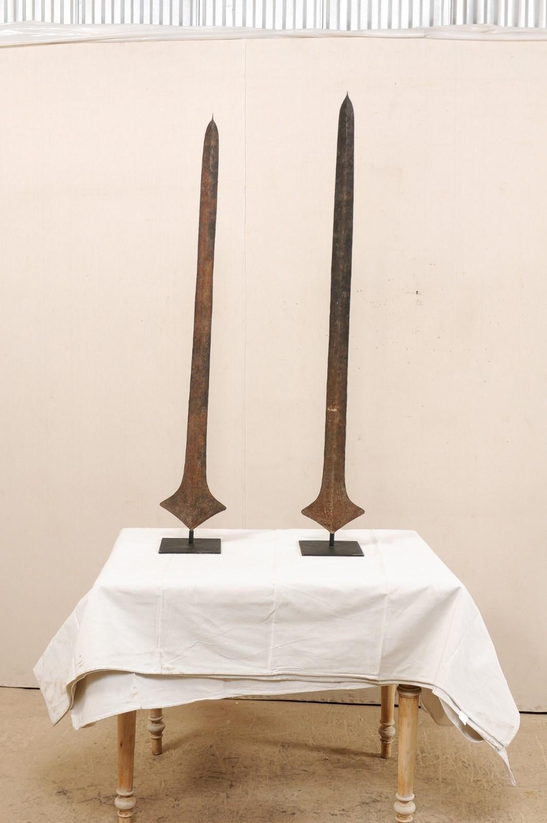 This is a pair of African iron currency blade or sword currency from the Nkutshu, Topoke & Songo Meno peoples, Democratic Republic of Congo (Zaire) which are nicely presented upon custom metal stands. Such blades were used by various tribal groups