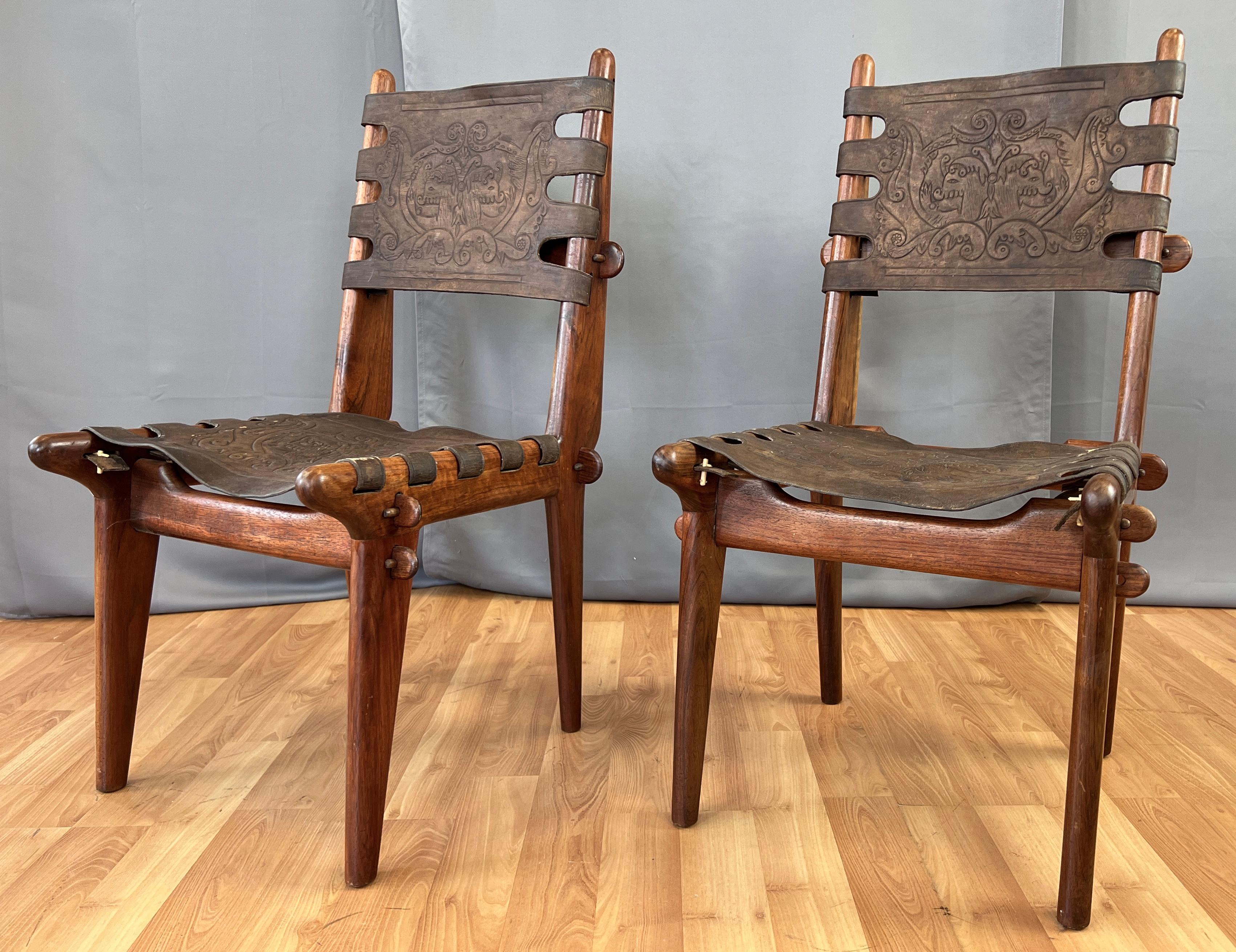 A pair of Angel Pazmino designed teak and leather chairs for Muebles De Estilo, located in Quito Ecuador.
Teak chair frames have wonderful wood grain, and striking form, held together with a system of interlocking joints and wooden pins. Sling