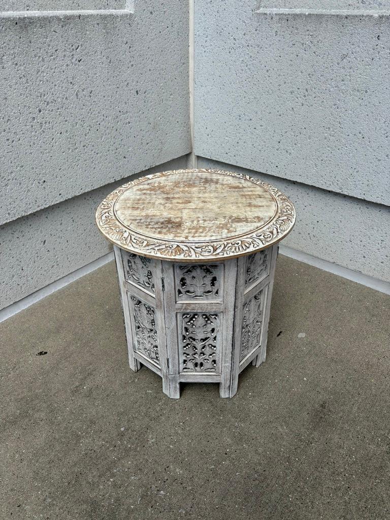 Pareja de mesas auxiliares redondas de estilo angloindio talladas y pintadas a mano. Las bases con grecas abiertas talladas, las tapas redondas con una bonita moldura decorativa floral. Con una superficie pintada de blanco frotada similar al