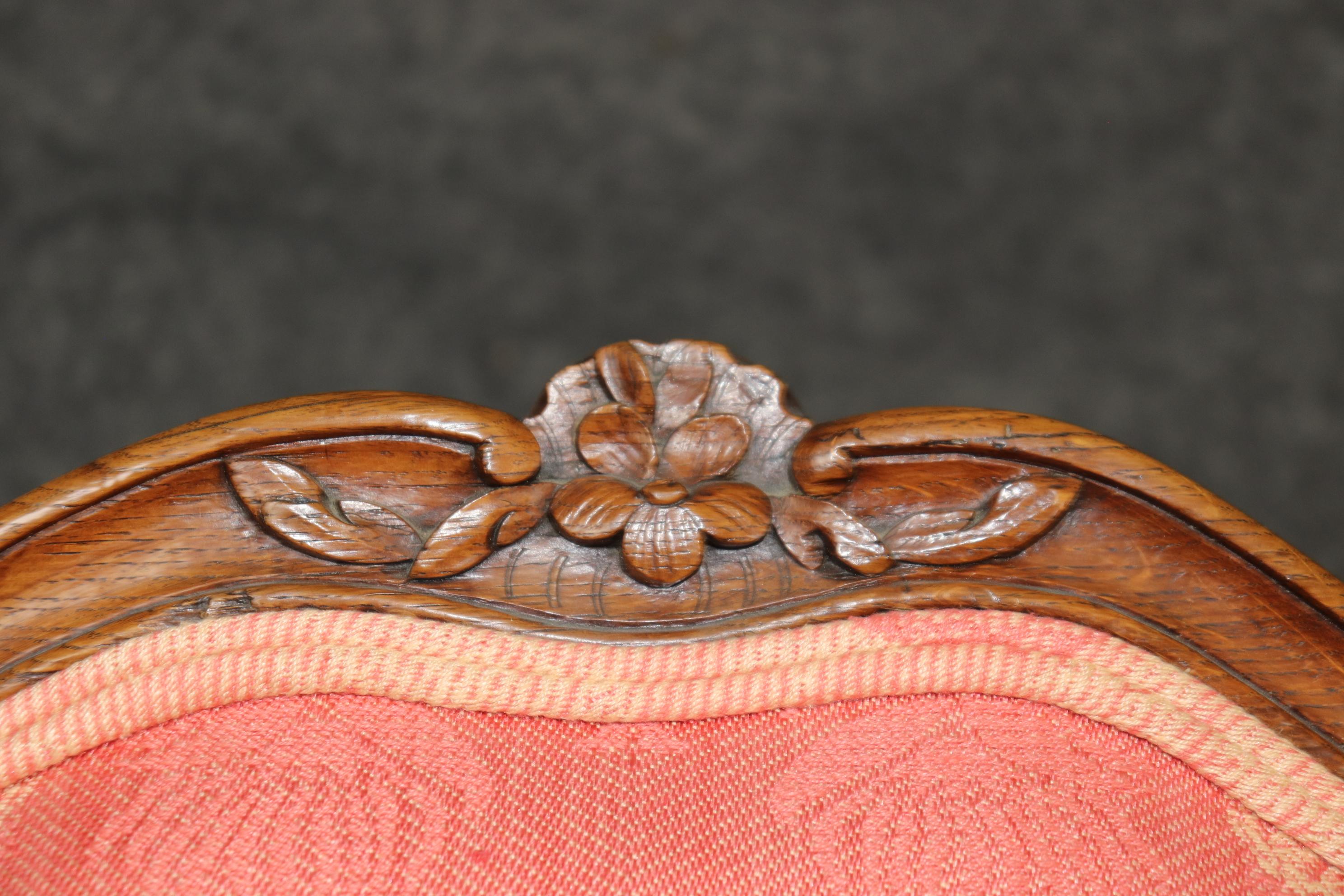 This is a fantastic pair of French-made period era Louis XV carved walnut chairs. They feature gorgeous Griffon upholstered seating and are in good original condition. They have mortice and tennoned joinery and incredible carving. The upholstery is