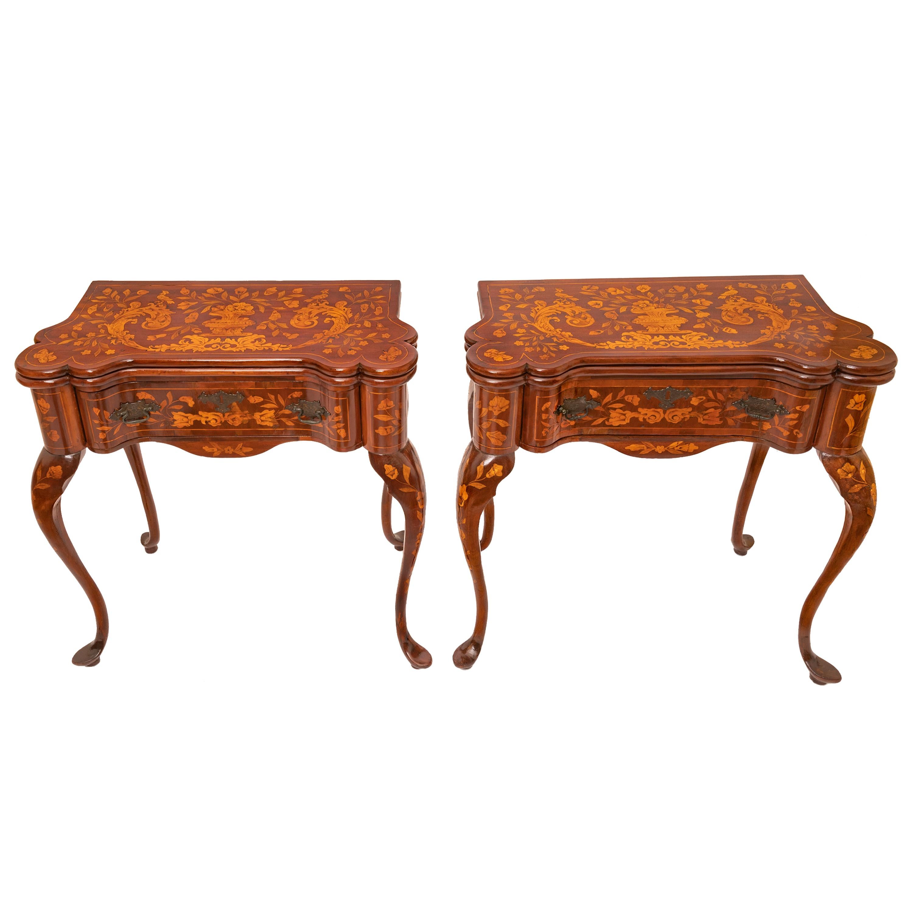 An exceptional & rare pair of antique early 19th century Dutch marquetry walnut card or game tables, circa 1820.
Each table is of reverse serpentine shape and having a hinged fold over top, both tops are sumptuously inlaid with a central flowering