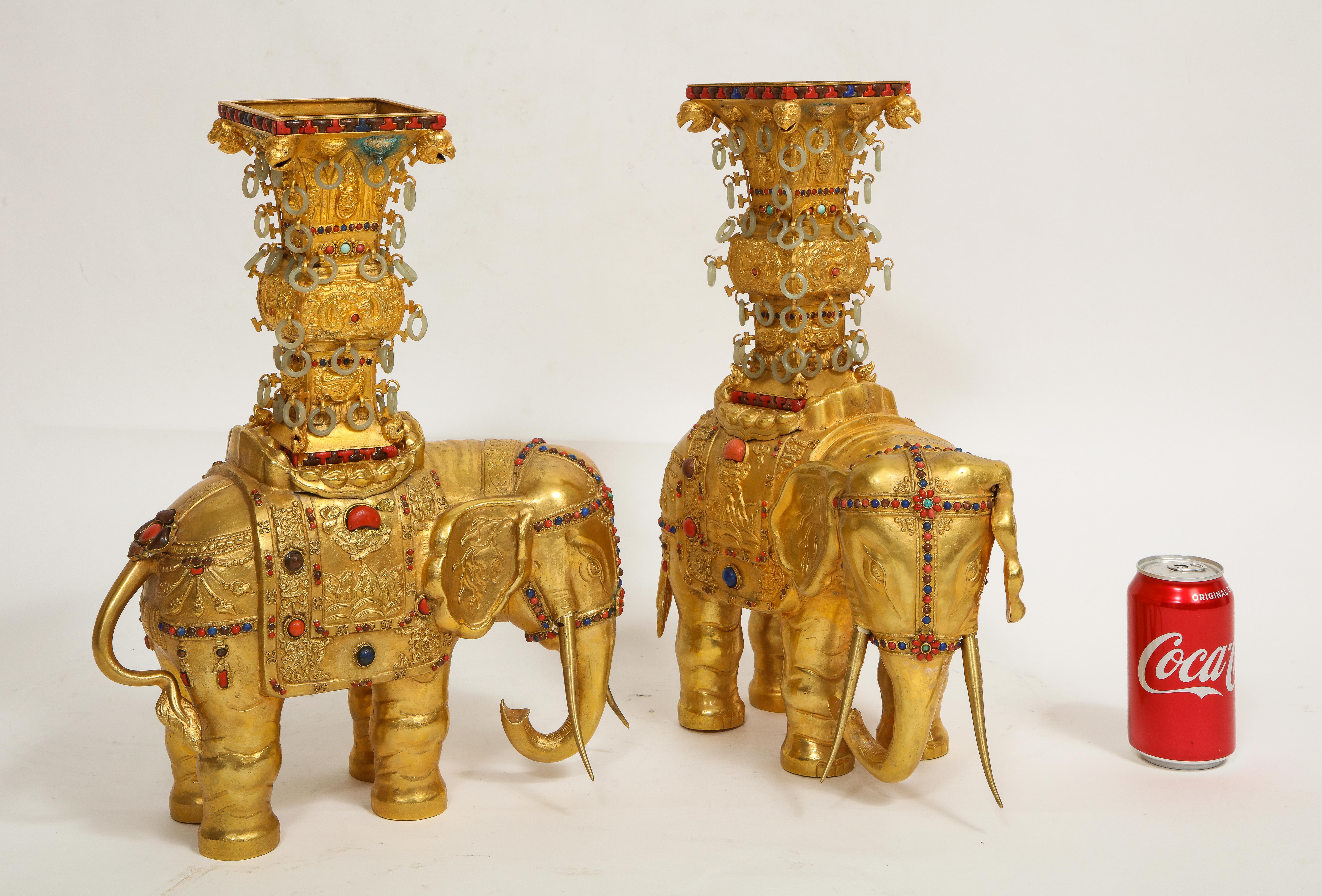 A Pair of Antique 20th Century Chinese Gilt Copper Elephant Form Censers with Jade Rings and Inset with Coral, Lapis Lazuli, Sandstone, and Turquoise. These gilt-bronze/copper censers are designed in the form of elephants. Each features bodies