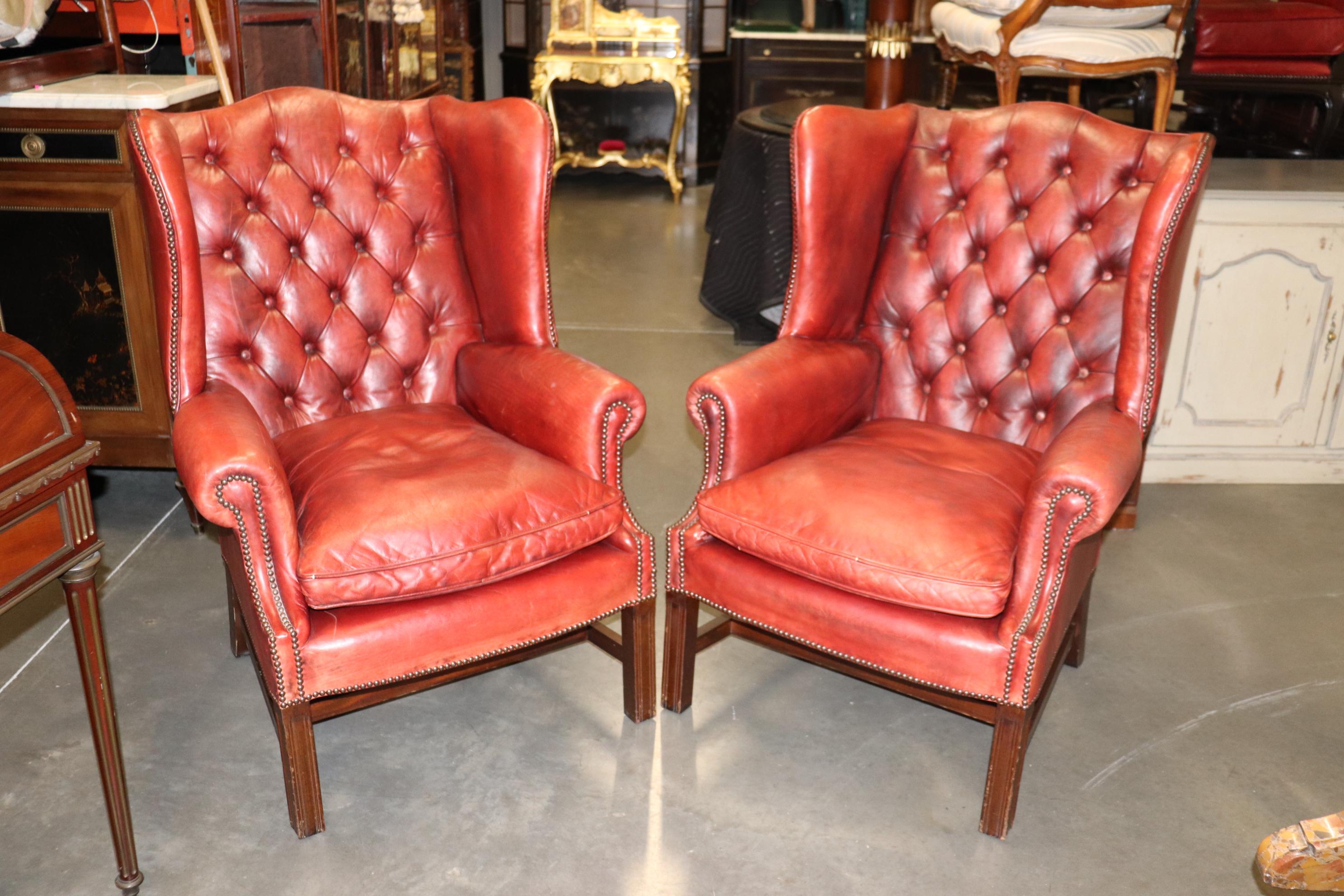 This is a gorgeous pair of antique 1920s era aged leather chairs in a gorgeous faded red with so much character and distressing that they have that 