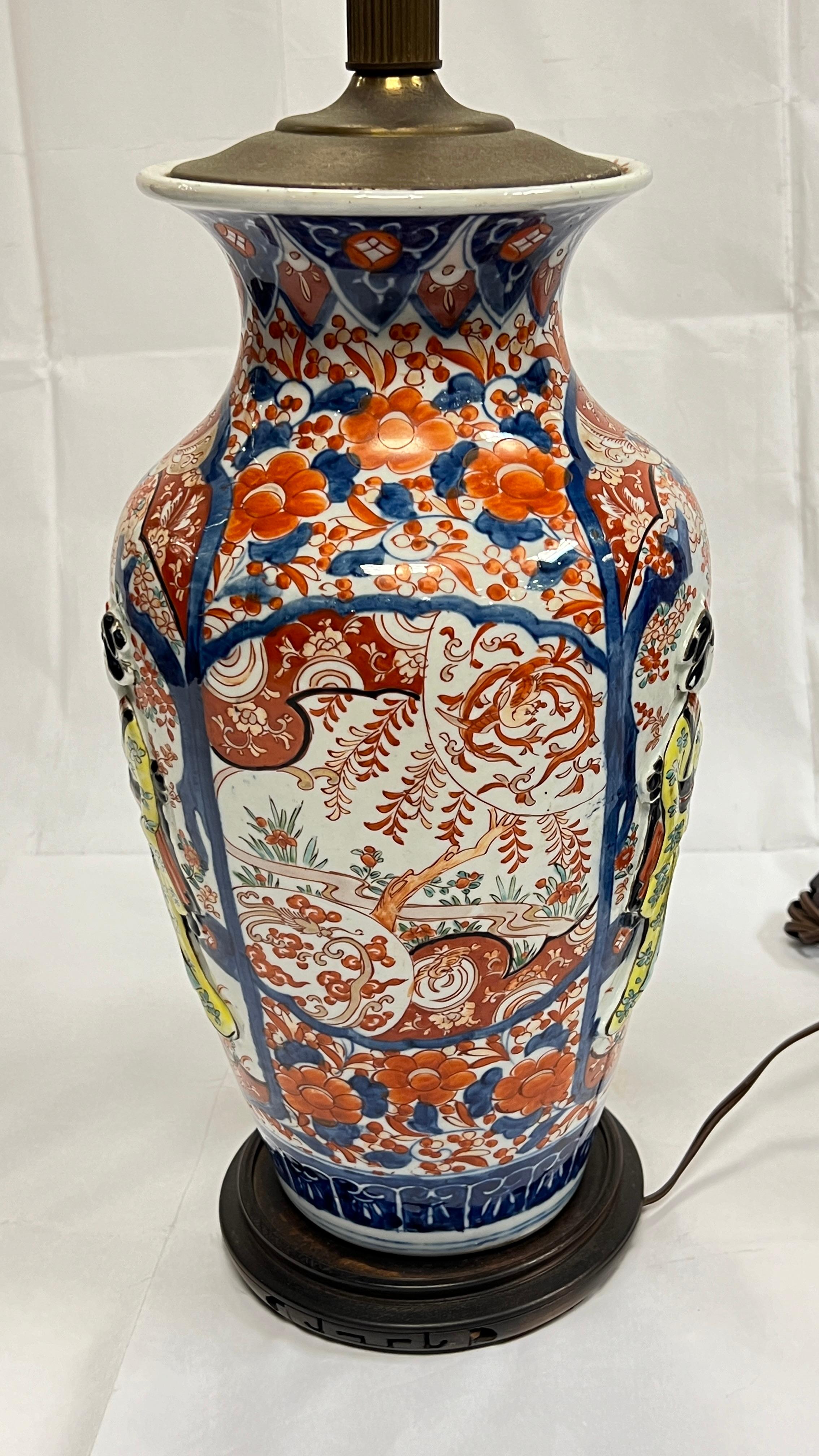 Pair of antique (19th century) Japanese Imari porcelain vases with raised figurative designs  later mounted as table lamps.