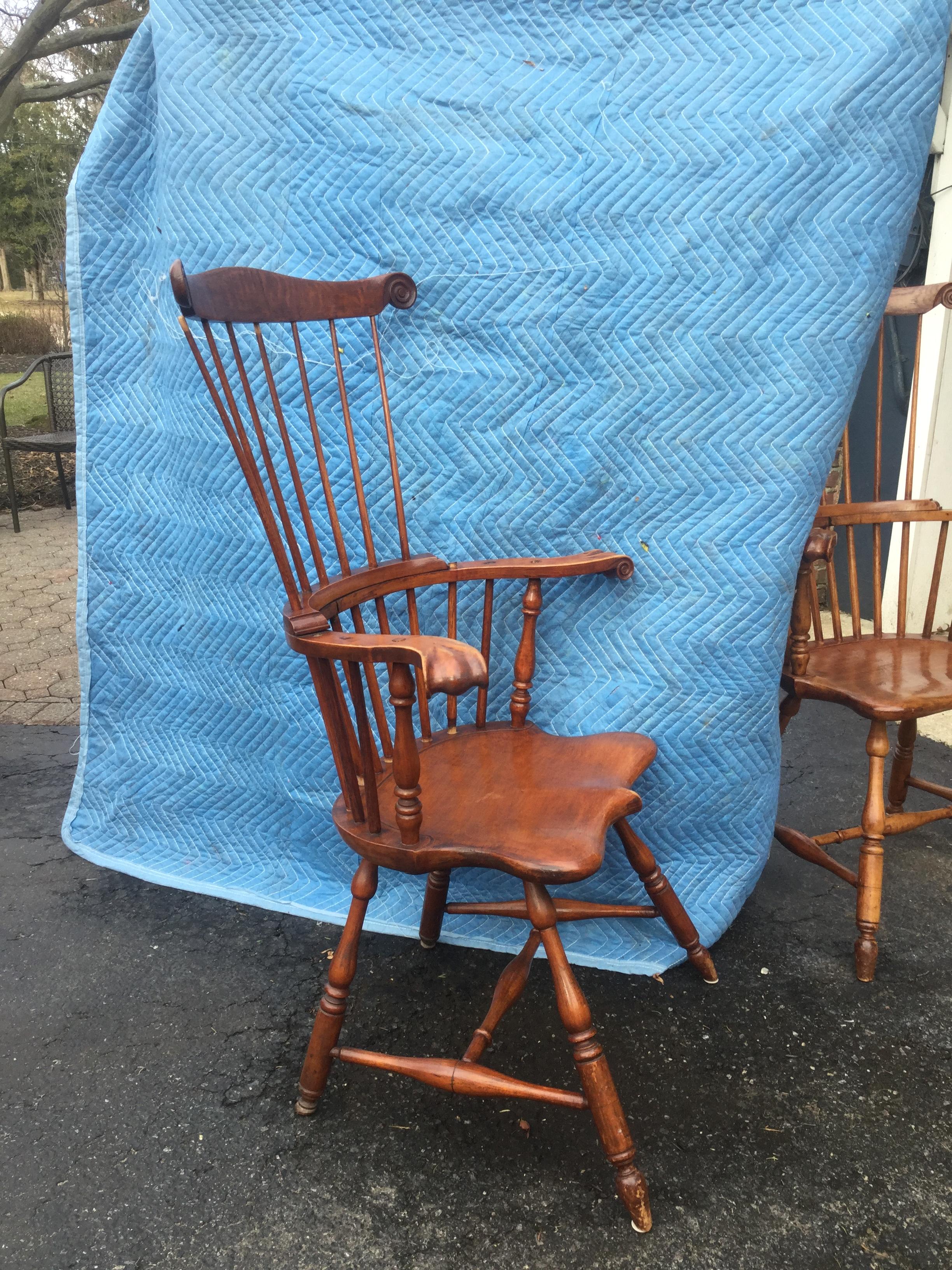 Stunning tall-back American antique Windsor chairs. Made of American maple, these traditional chairs feature a curved top rail and double spindle backs over splayed turned legs. Elegant arms turn outward while the scalloped solid seat provides