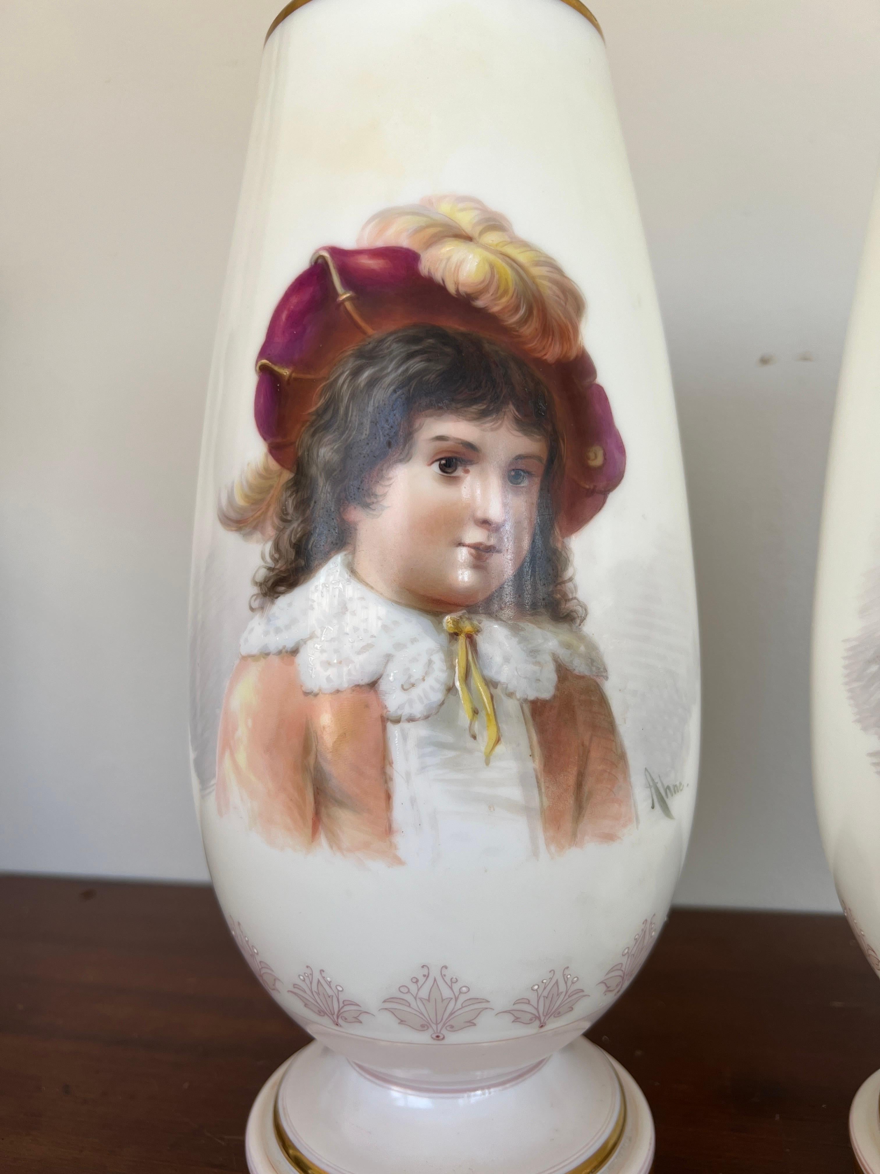 Josef Ahne (Bohemian, 1830-1909). A pair of white opaline vases hand decorated with portraits of young children. They are accented by gone tone rims to the mouth and lower foot. Each signed “Ahne”.