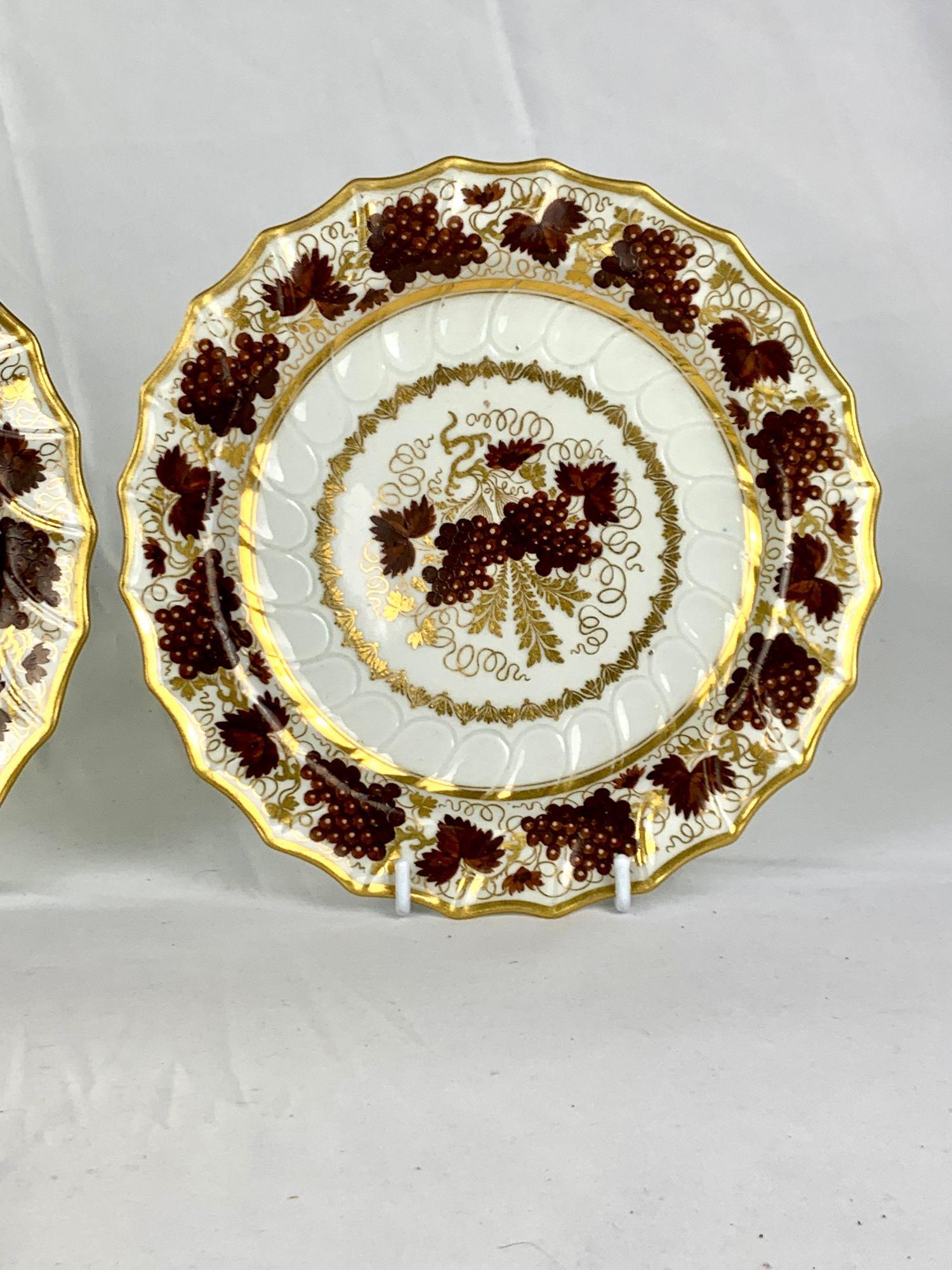 Questa coppia di piatti di porcellana Barr Worcester è stata dipinta a mano nella fabbrica Warmstry House sul fiume Severn a Worcester, in Inghilterra, tra il 1792 e il 1803.
Ogni piatto presenta grappoli d'uva di colore marrone intenso incorniciati