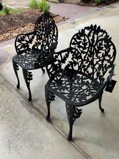Paar antike schwarze Eisen-Gartenstühle mit Eichel- und Blattwerkmuster und Faux Bois-Design