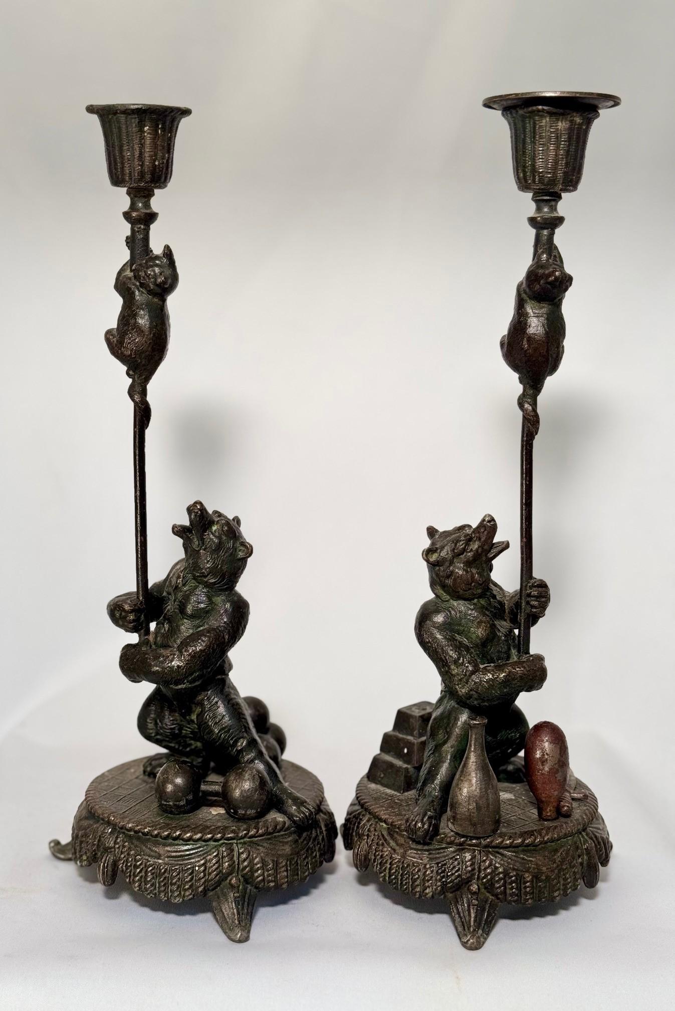 Superb and rare pair of zoomorphic candlesticks from the late 19th or early 20th century. Representing a circus bear holding a pole, with a cub climbing up high on the pole, ending in a candle cup. The bear has a open mouth as if shouting directions