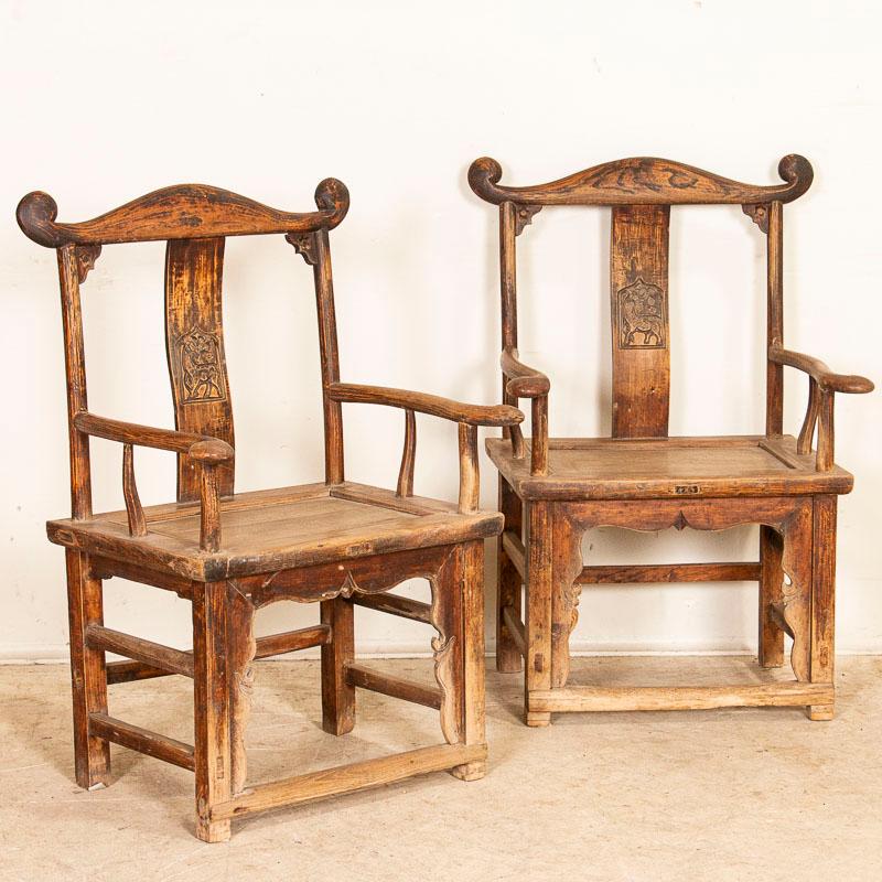 This attractive pair of arm chairs were crafted in the early to mid 1800's in China. The majority of the original darker finish has been worn away through generations of use, leaving a soft, smooth organic feel to the chairs. Note the traditional