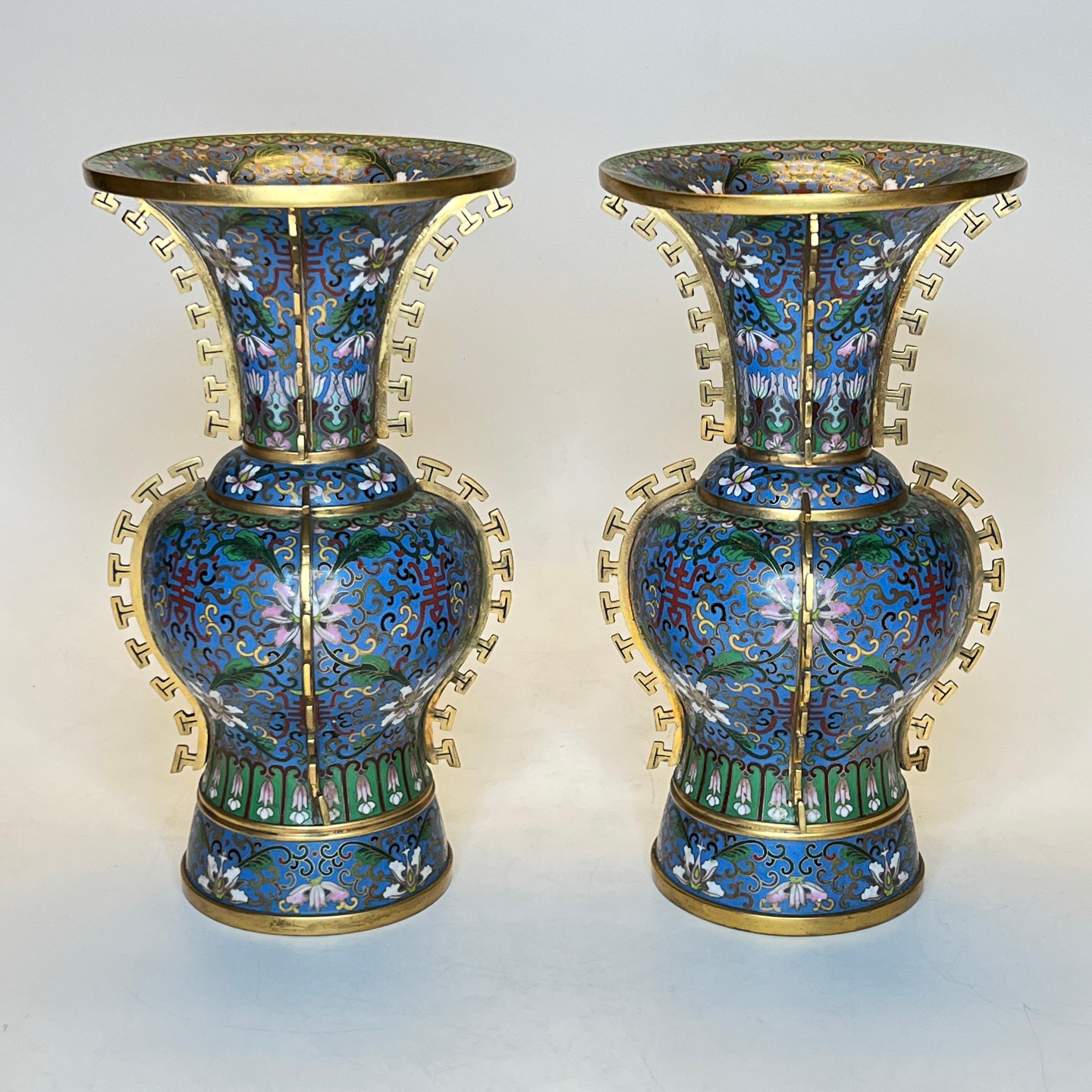 Pair Chinese cloisonne enamel vases with floral designs on blue ground and gilt mounts representing stylized dorsal fins of a dragon.