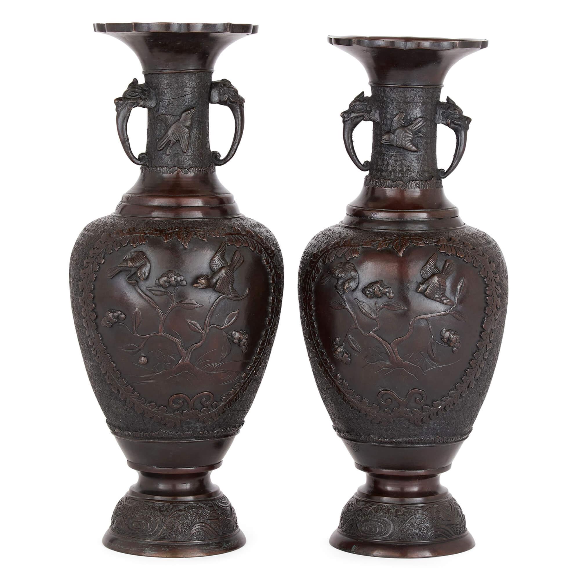 Paire de vases anciens en bronze brun de Chine Motifs floraux d'oiseaux en relief Animaux
A.I.C., c. 1900
Hauteur 45 cm, diamètre 18 cm
Cette paire de vases chinois en bronze se distingue par sa forme ovoïde, ses bords évasés en forme de pétales et